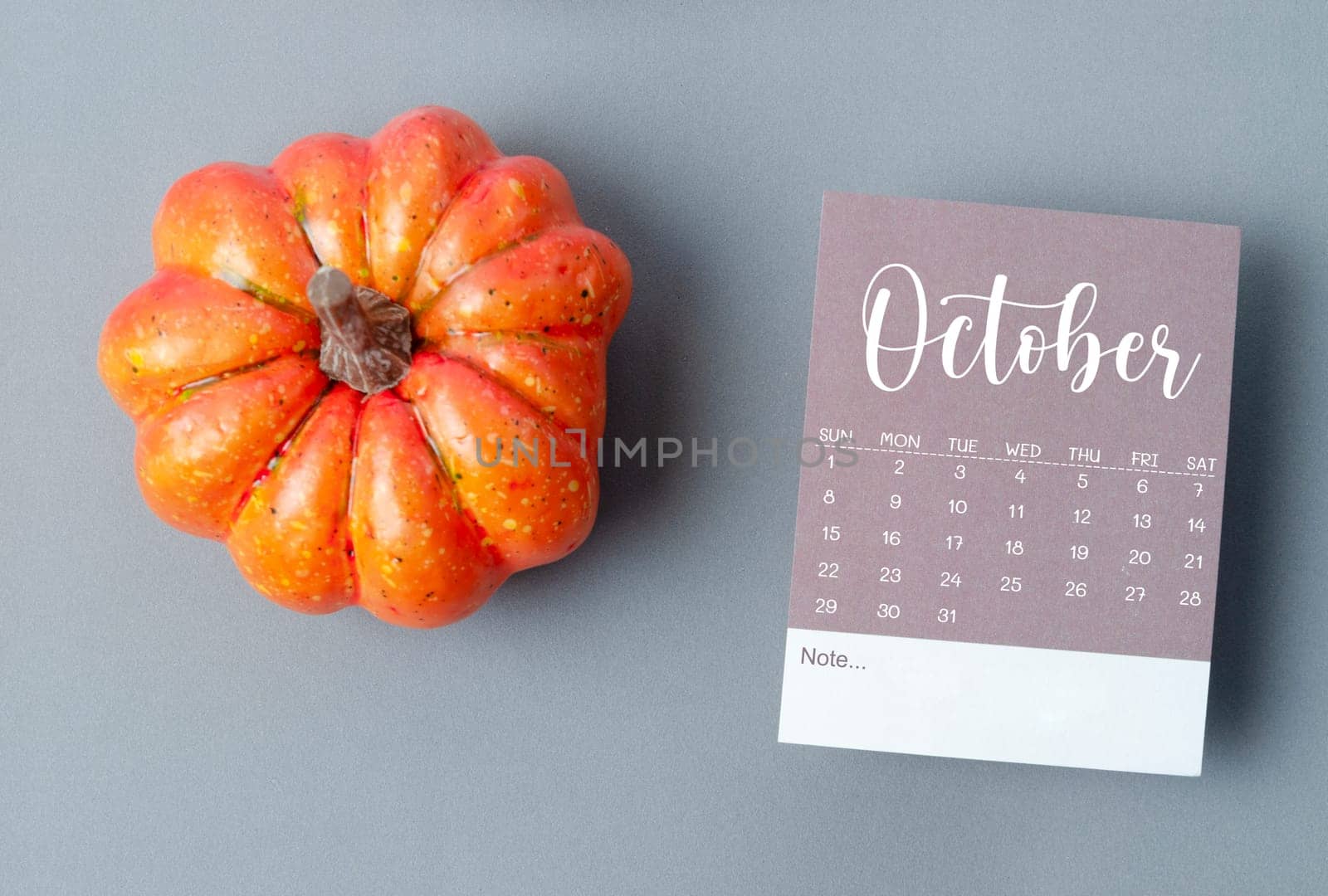 The October 2023 Calendar and pumpkins on gray color cardboard background. by Gamjai