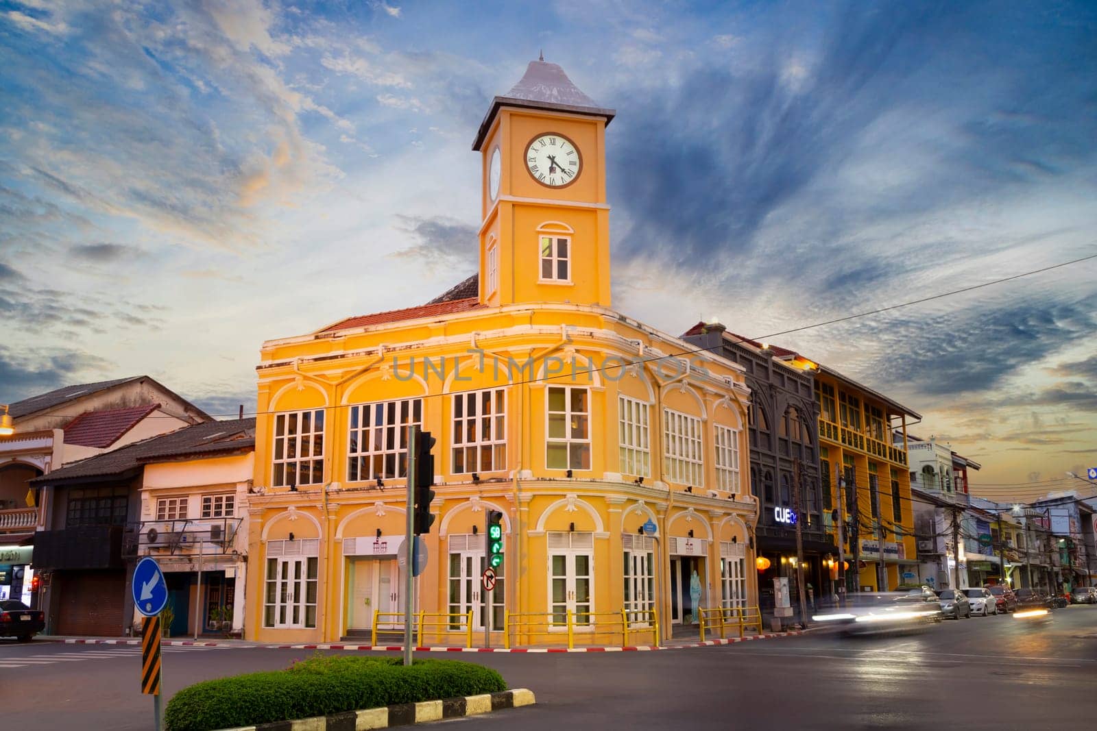 The Phuket Thailand , September 14th 2020 ; Landmark chino-portuguese clock tower in phuket old town, Thailand, with light trails on road in twilight time. by Gamjai