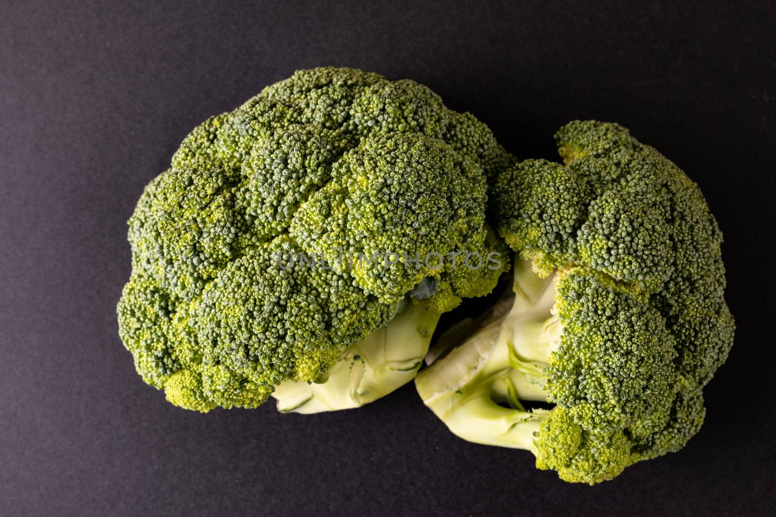 Overhead close-up of broccolis on black background by Wavebreakmedia