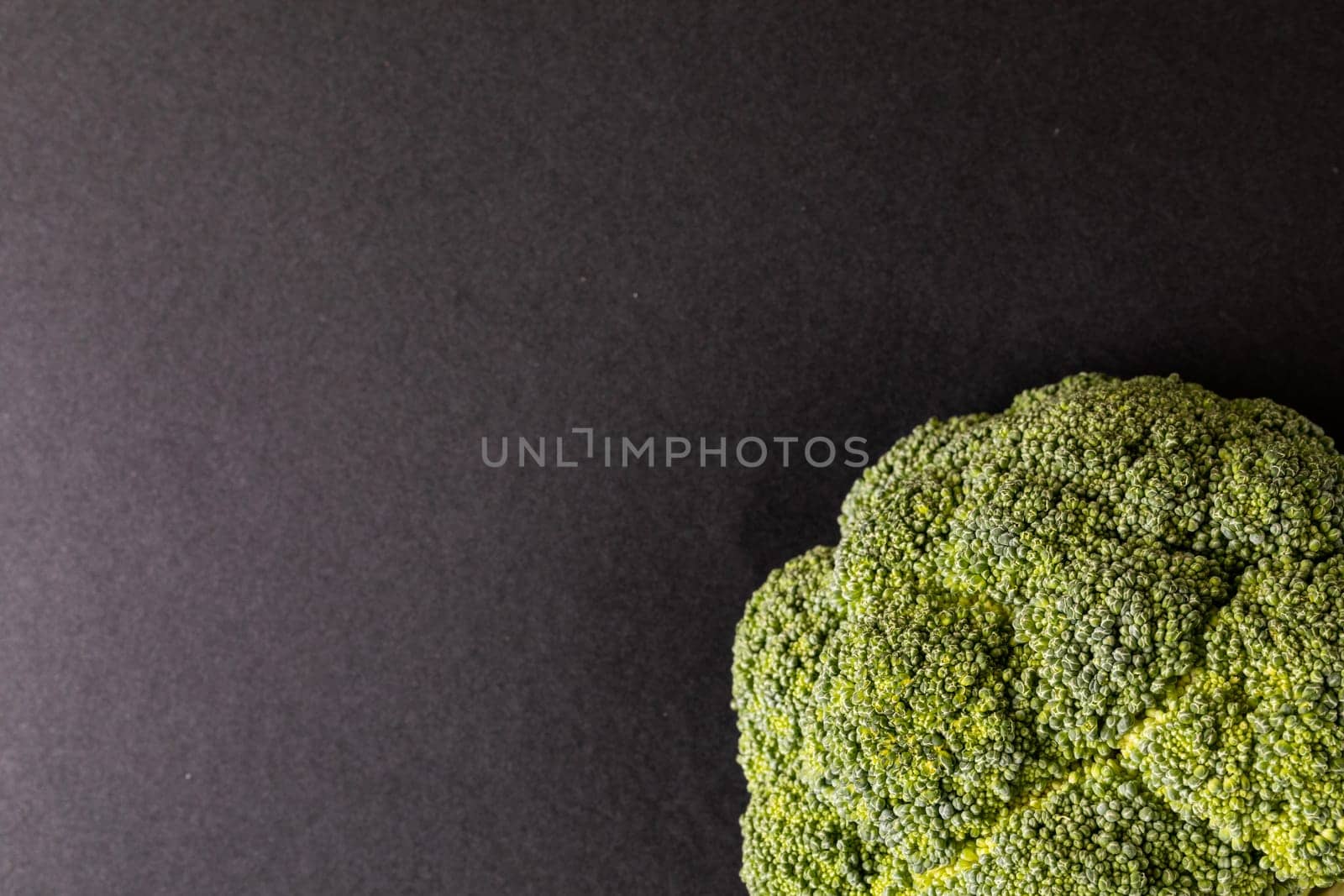 Overhead close-up of broccoli on black background with copy space. unaltered, vegetable, healthy food, raw food and organic concept.