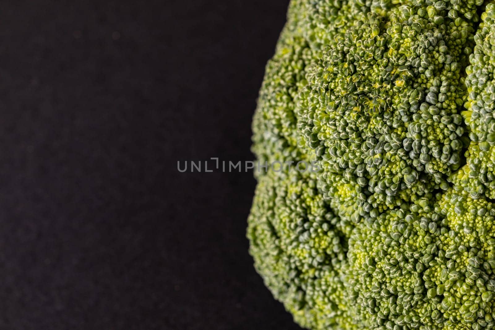 Extreme close-up of fresh green broccoli on black background with copy space. unaltered, vegetable, healthy food, raw food and organic concept.