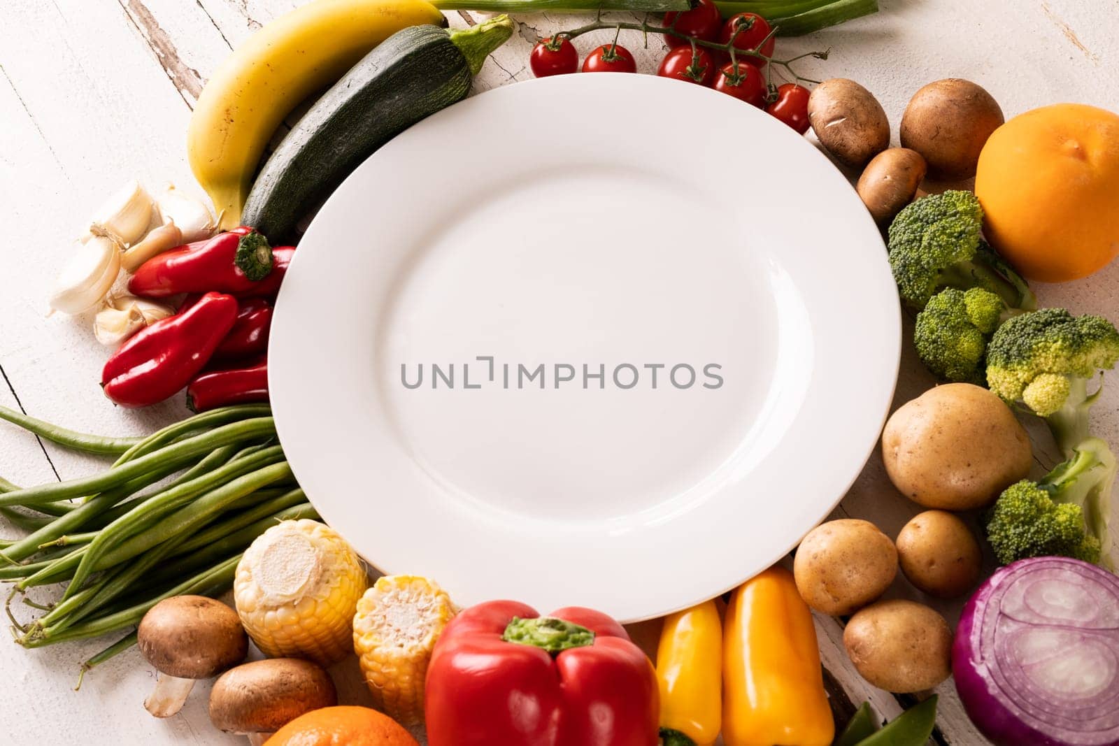 High angle view of empty white plate amidst various vegetables and fruits on table. unaltered, vegetable, healthy food, raw food, fruit, variation and organic concept.