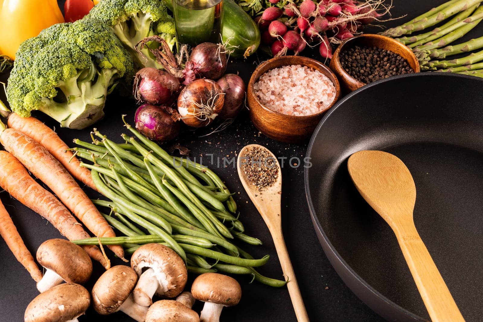 Frying pan with spices and various vegetables and oil bottle on table. unaltered, vegetable, healthy food, raw food, variation and organic concept.