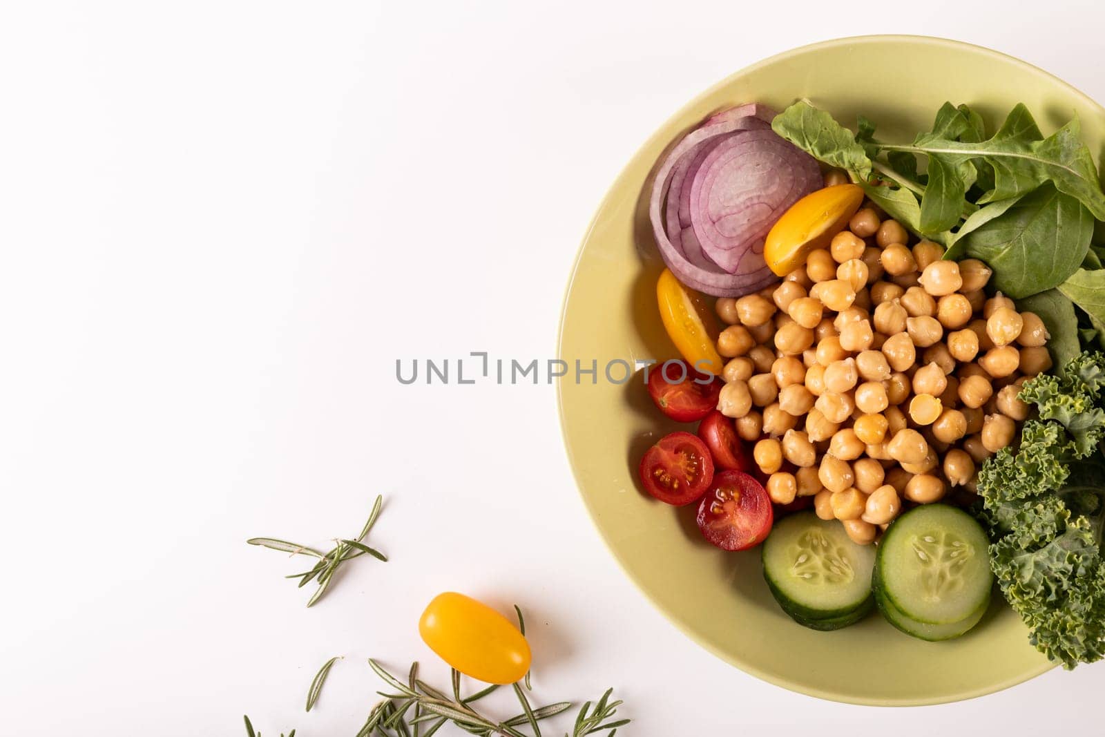 Overhead view of fresh healthy food in bowl by herb on white background, copy space. unaltered, food, studio shot, healthy eating, organic.