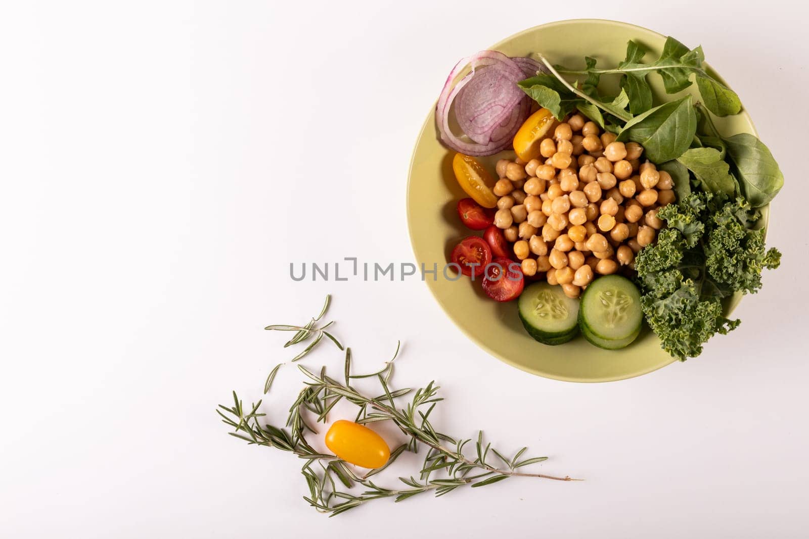 Directly above shot of fresh healthy food in bowl by herb on white background, copy space by Wavebreakmedia