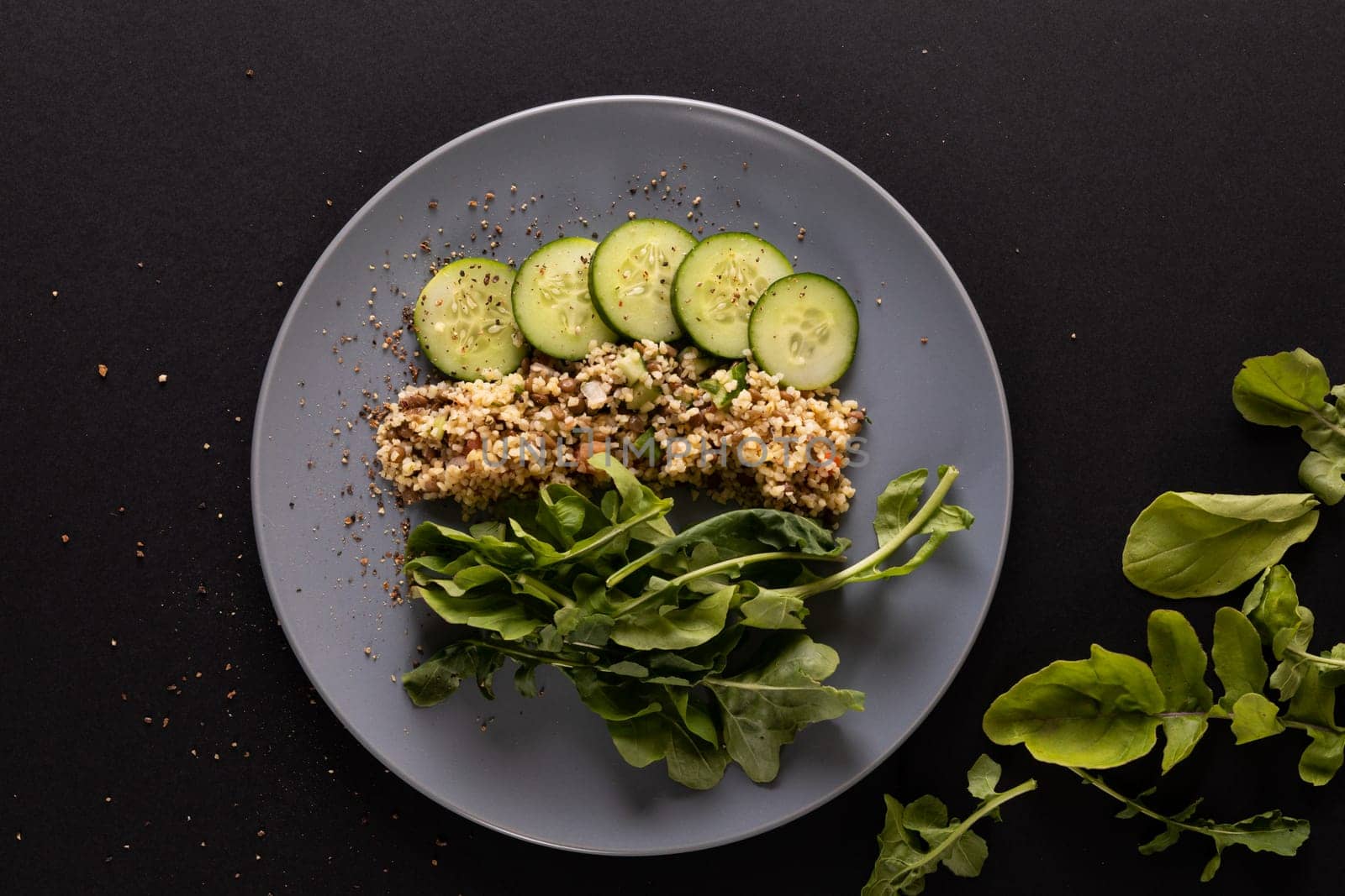 Overhead view of healthy food in plate on black background, copy space by Wavebreakmedia