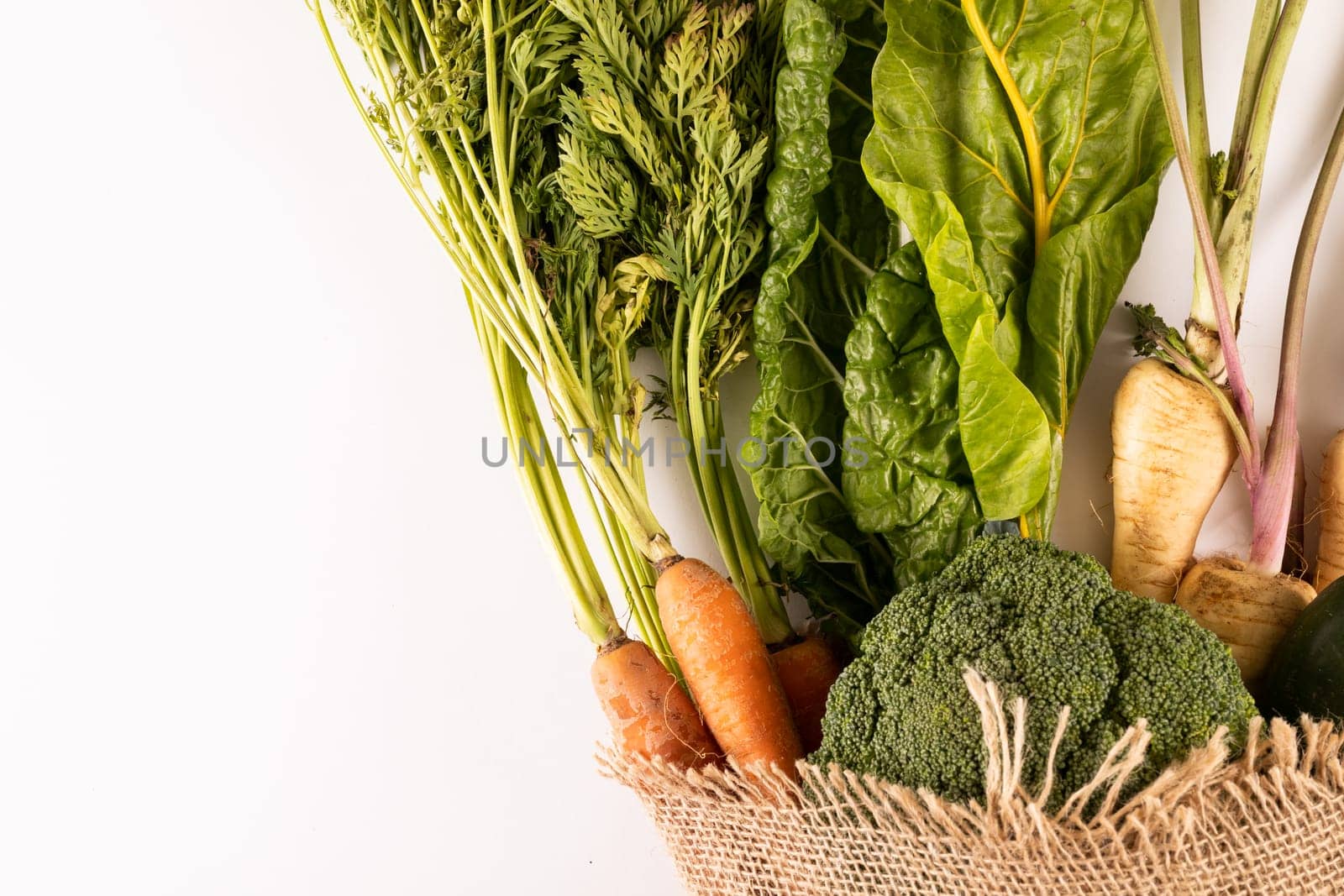 Overhead view of fresh organic vegetables with burlap on white background, copy space. unaltered, food, healthy eating, organic.