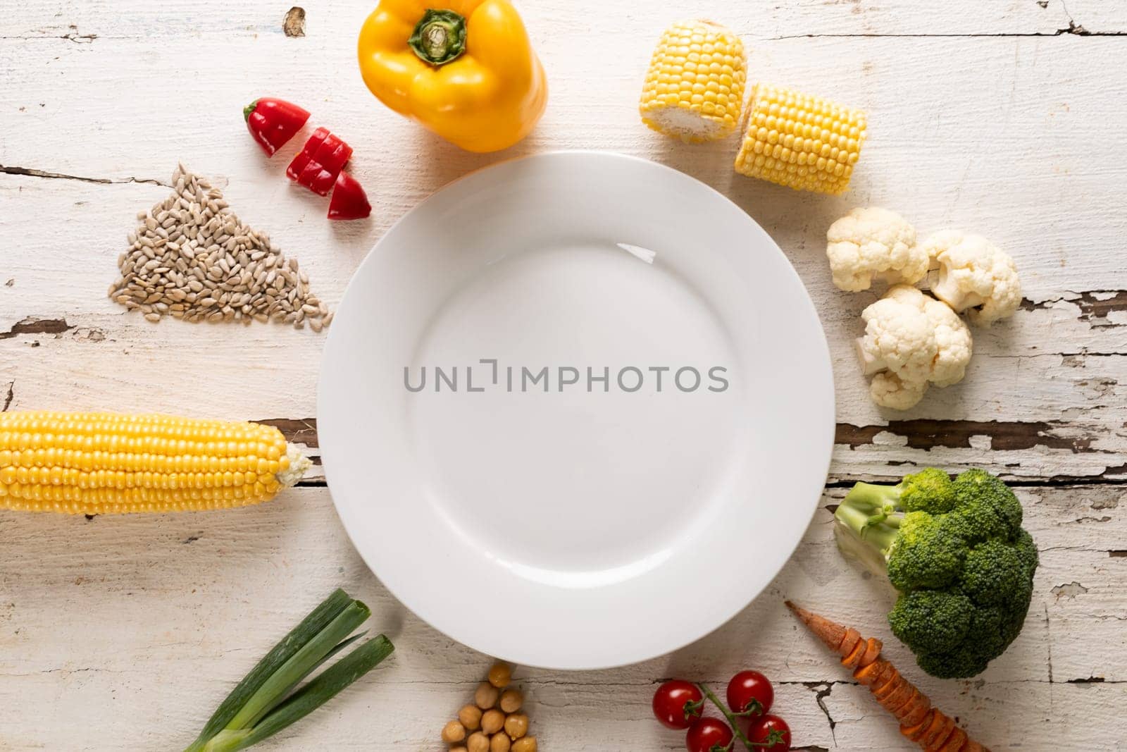 Overhead view of ingredients arranged around white empty plate on table, copy space. unaltered, food, preparation, healthy eating.