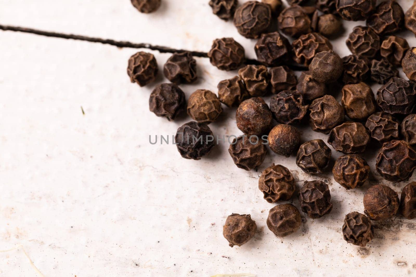High angle view of black pepper on white table, copy space. unaltered, food, spice, ingredient.