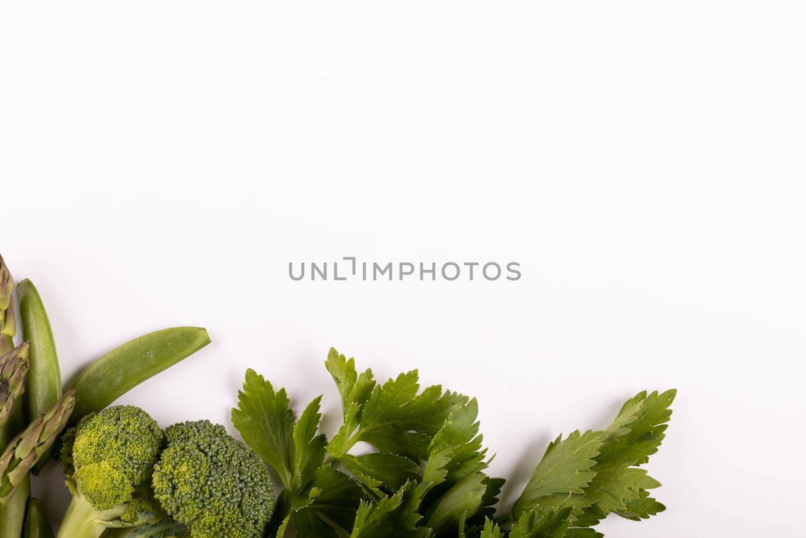 Overhead view of various green vegetables on white background, copy space. unaltered, healthy eating, food, organic, studio shot.