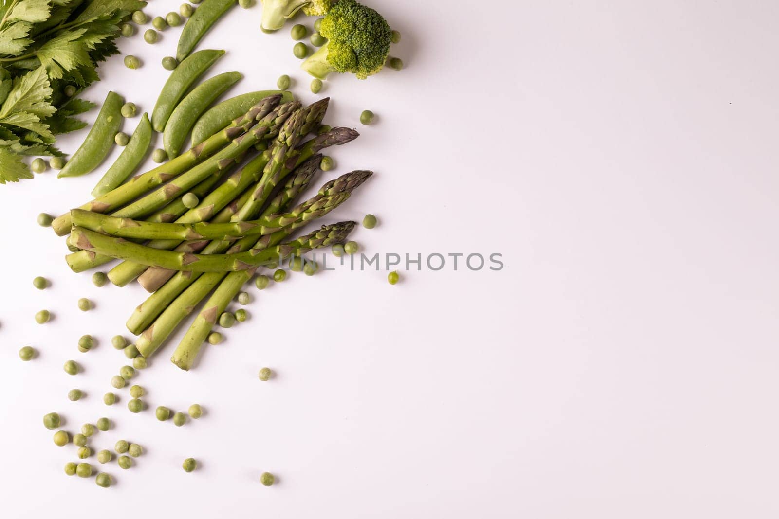 Overhead view of fresh asparagus and broccoli by copy space on white background by Wavebreakmedia