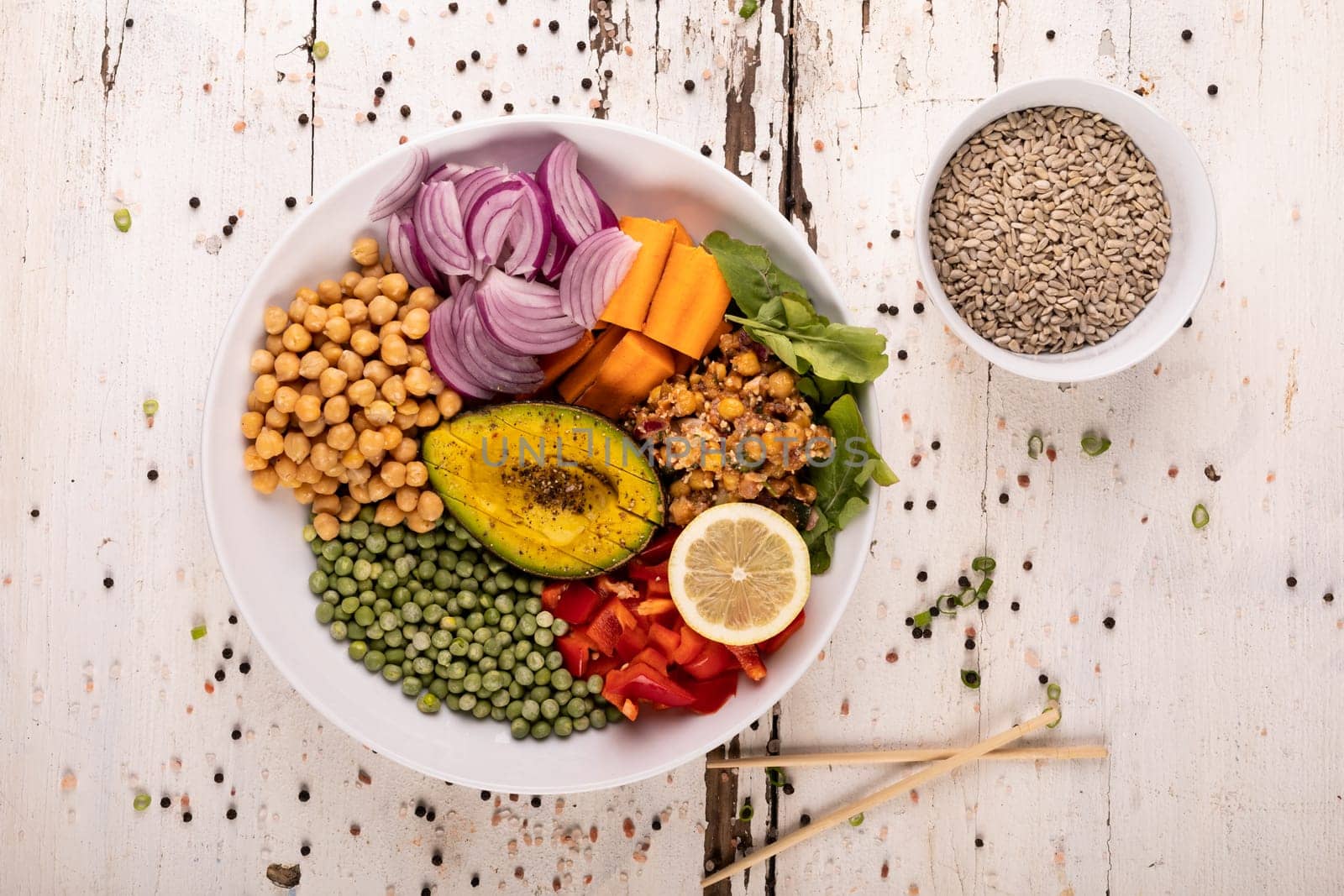 Directly above view of raw meal in bowl surrounded by peppercorn on white background. unaltered, food, healthy eating, organic concept.