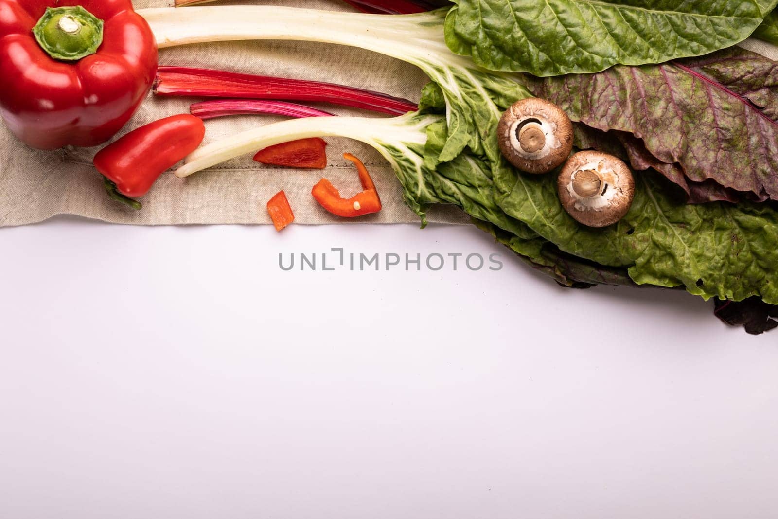 Directly above view of fresh chard with peppers and mushrooms by copy space on white background. unaltered, food, healthy eating, organic concept.