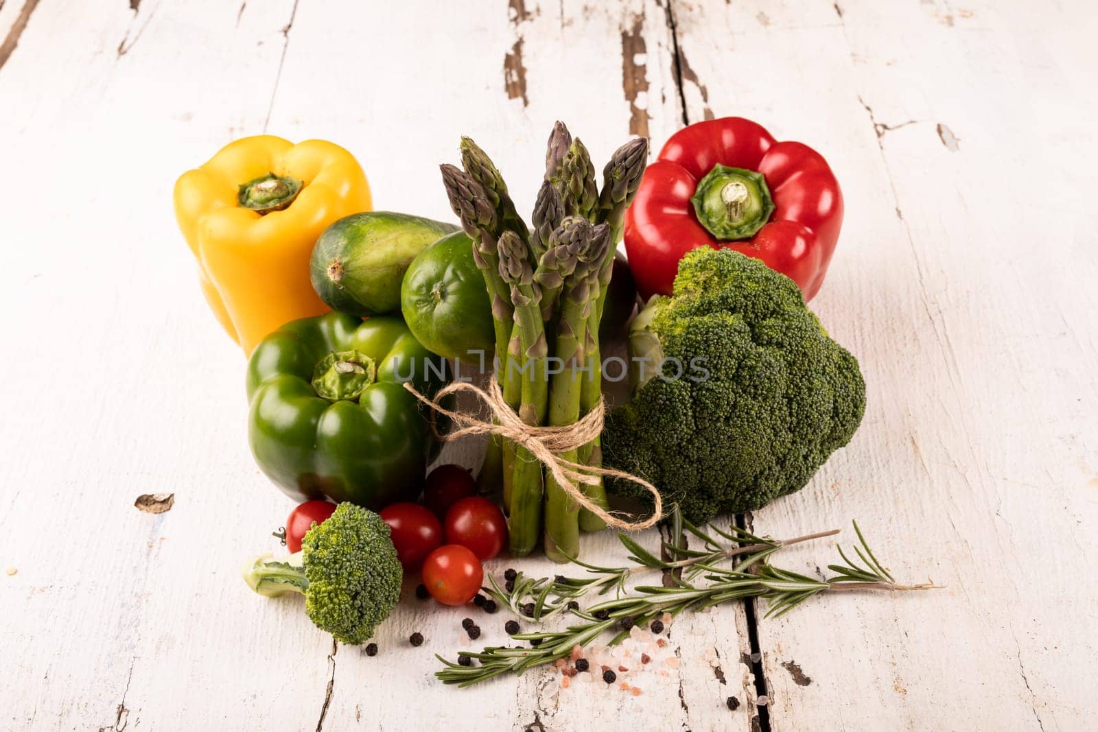 High angle view of fresh organic vegetables on white wooden table by Wavebreakmedia
