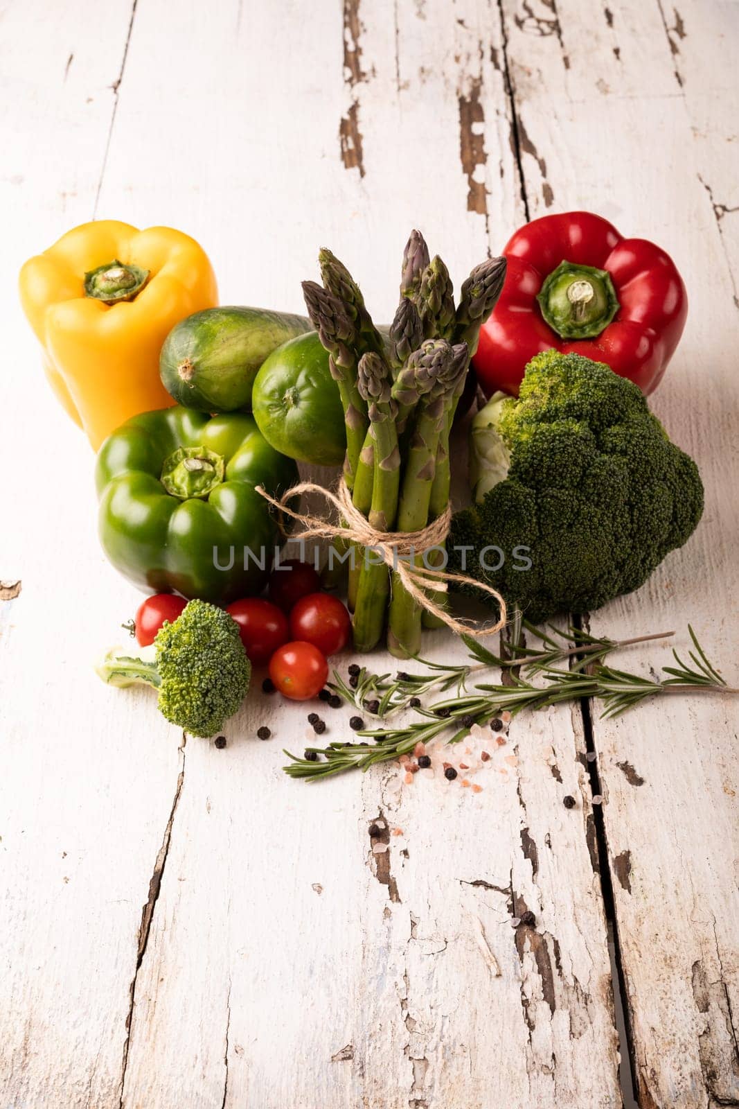 High angle close-up view of fresh organic vegetables on white wooden table by Wavebreakmedia