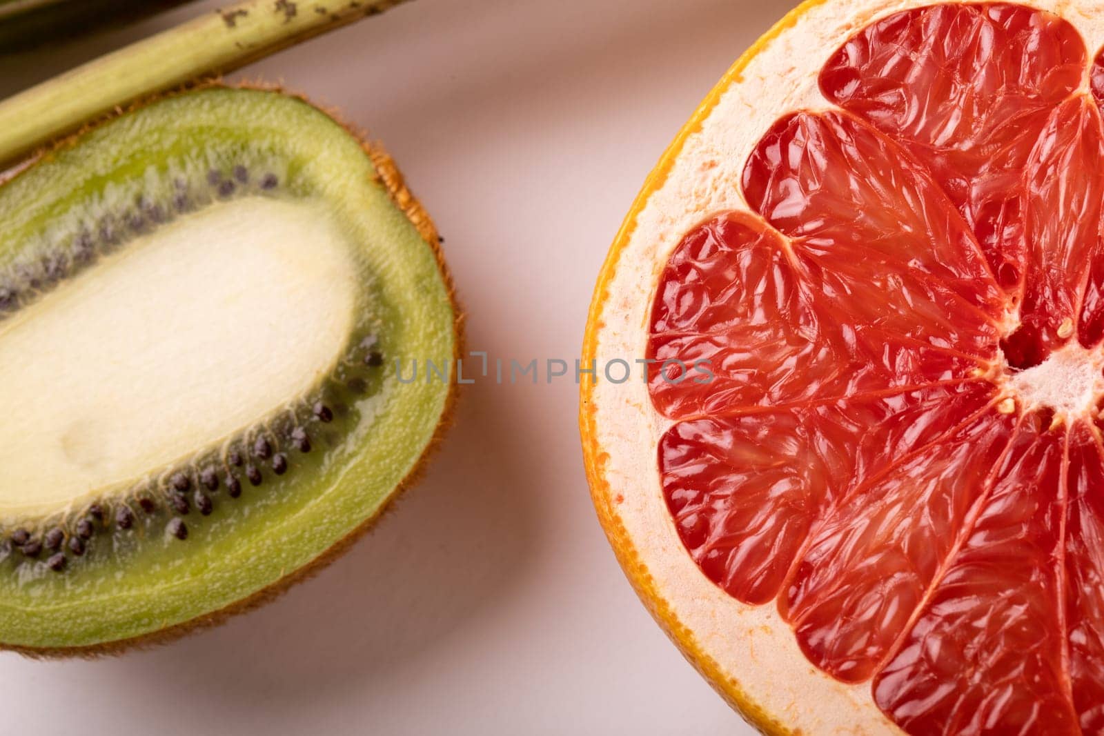 Overhead view of fresh grapefruit and kiwi halves on white background. unaltered, food, healthy eating, organic concept.