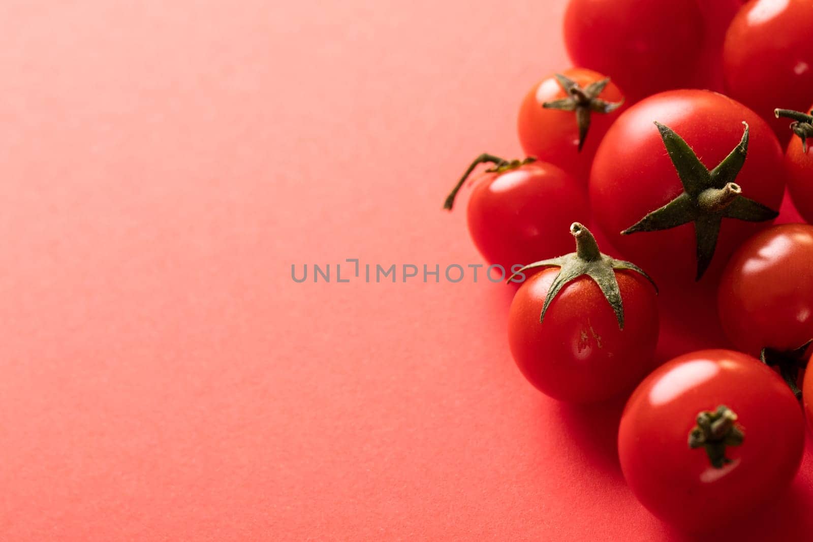 High angle close-up view of fresh red tomatoes by copy space on pink background by Wavebreakmedia