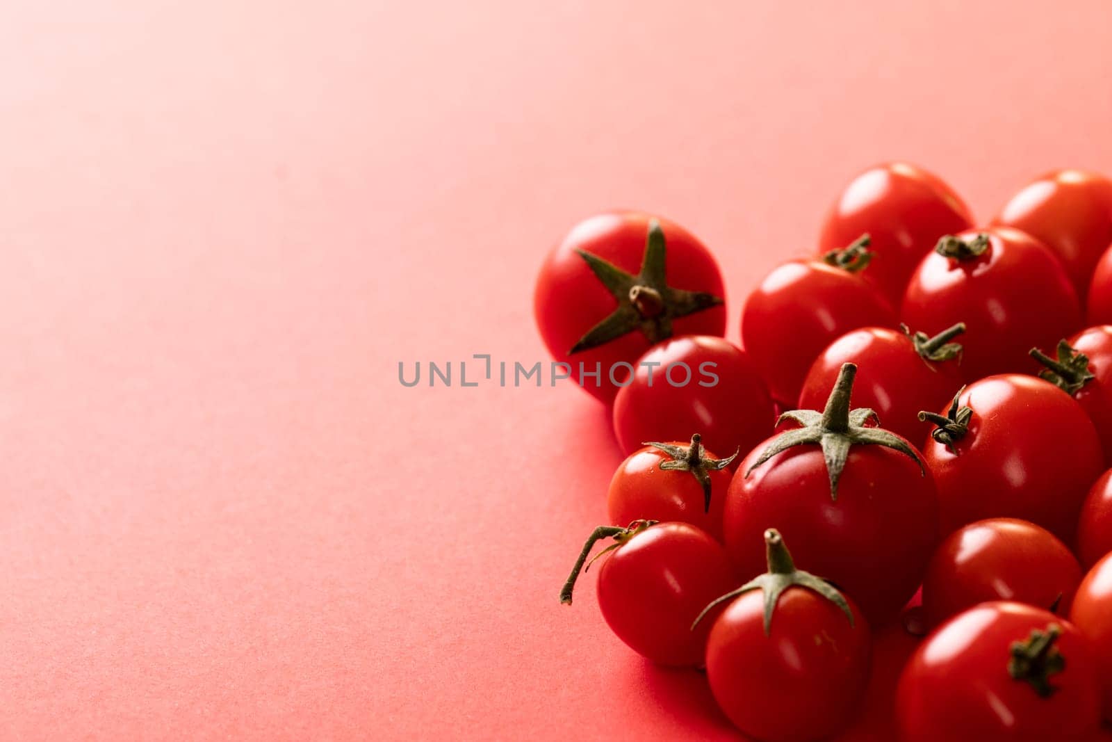 High angle close-up view of fresh red tomatoes by copy space over pink background by Wavebreakmedia