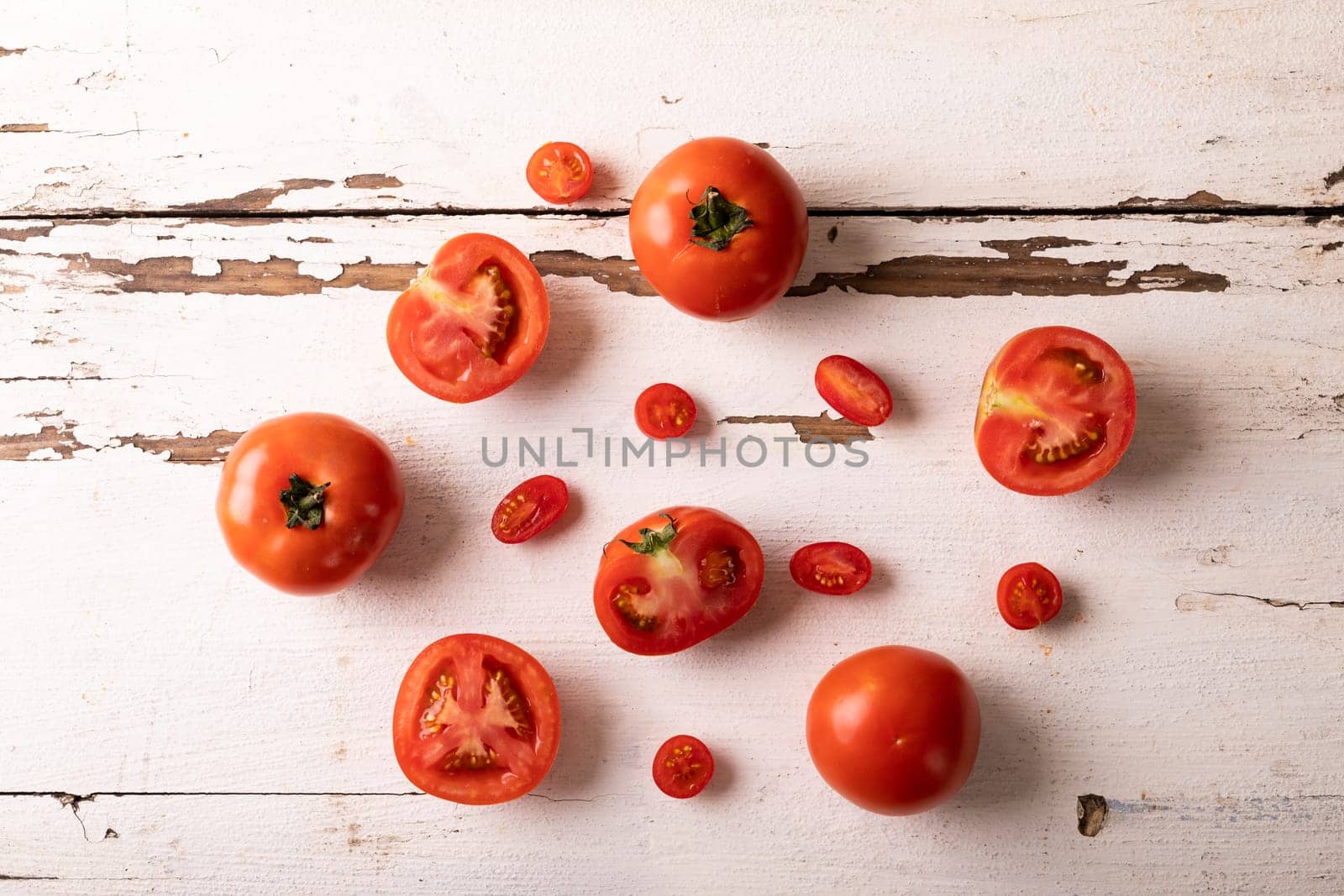 Overhead view of fresh tomato variations on white wooden table by Wavebreakmedia