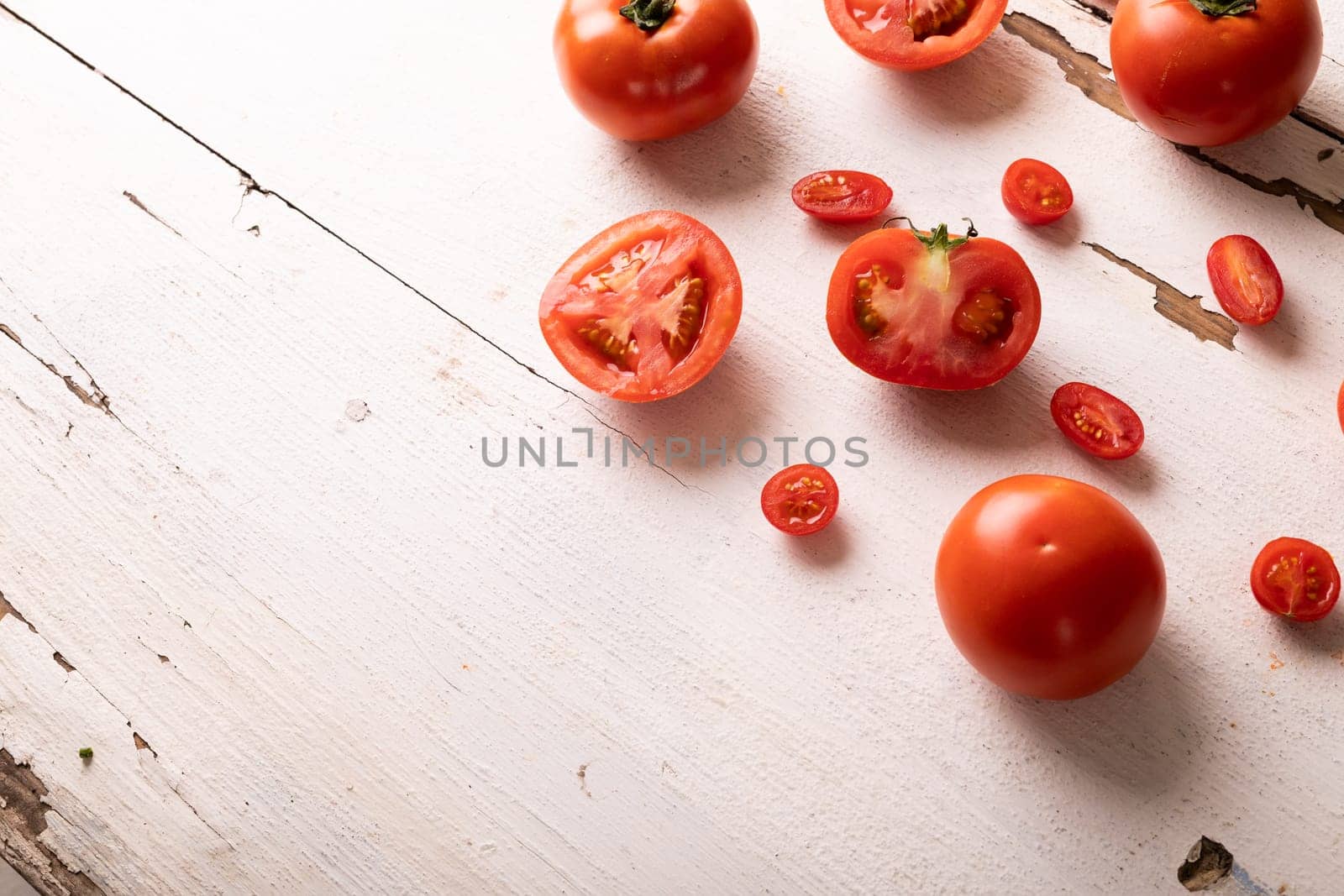 Overhead view of fresh red tomato variations on white wooden table. unaltered, food, healthy eating, organic concept.