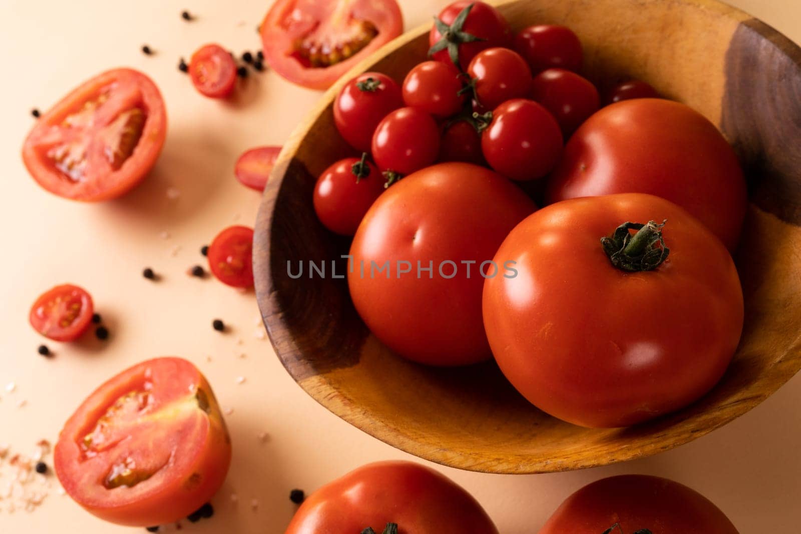 High angle view of fresh tomato variations in bowl by peppercorn on table. unaltered, food, healthy eating, organic concept.