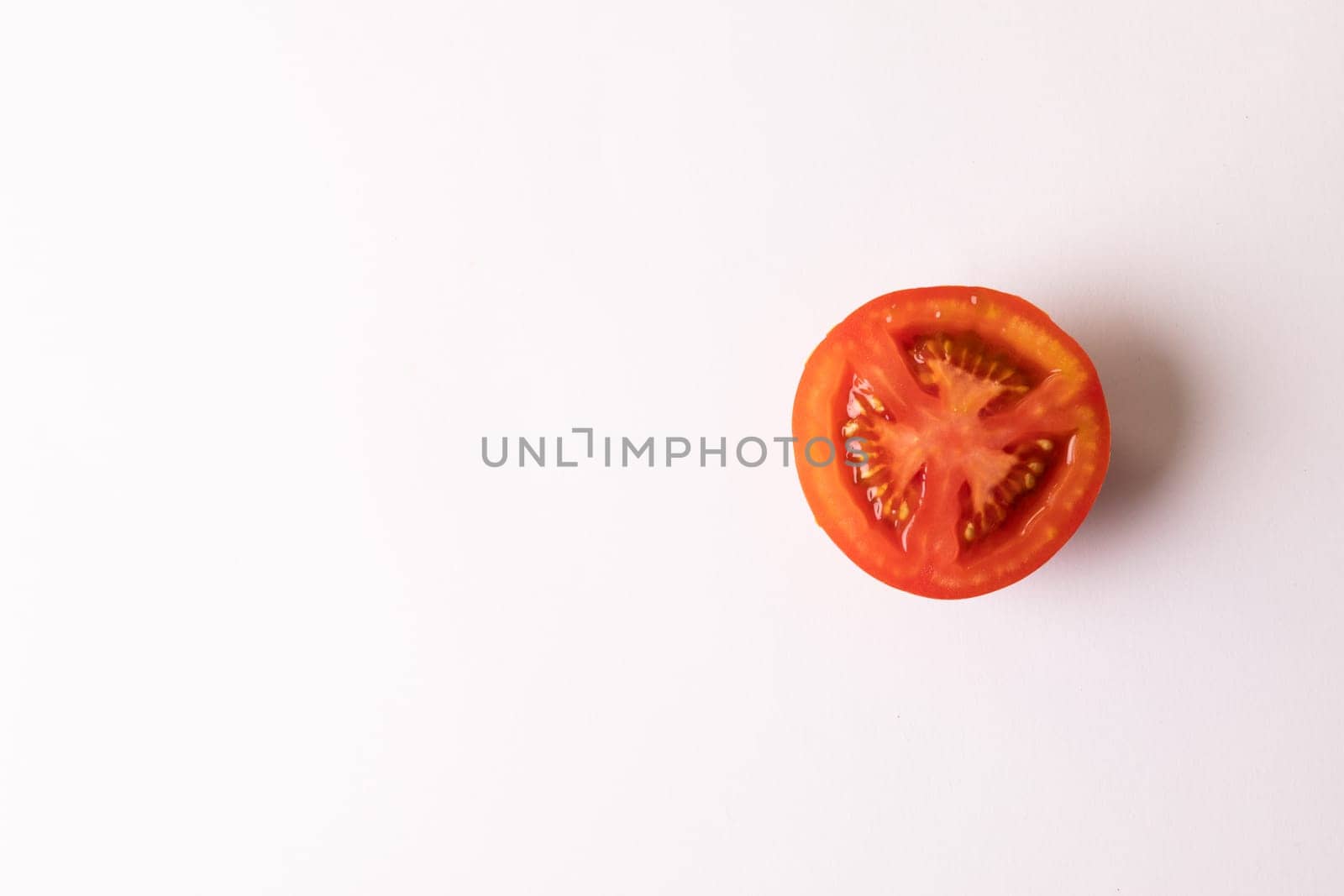 Directly above view of fresh red single tomato half by copy space on white background. unaltered, food, healthy eating, organic concept.