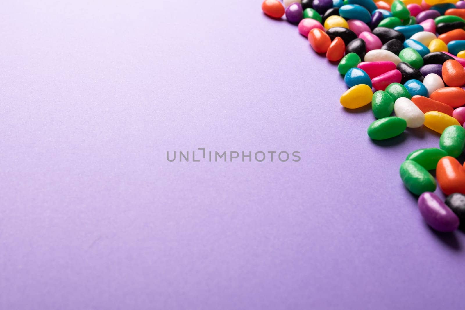 Close-up of copy space by multi colored sweet candies on purple background by Wavebreakmedia