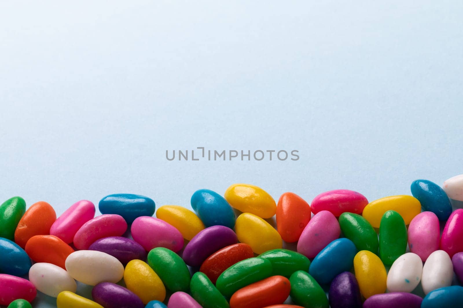 Directly above view of copy space and multi colored candies over blue background by Wavebreakmedia