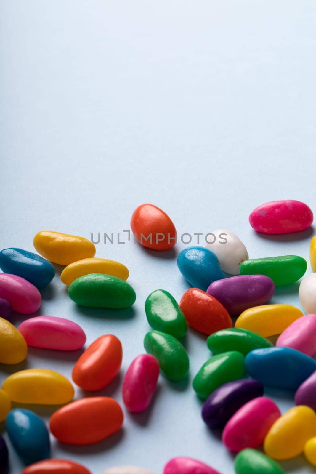 Close-up of multi colored candies on blue background against copy space by Wavebreakmedia