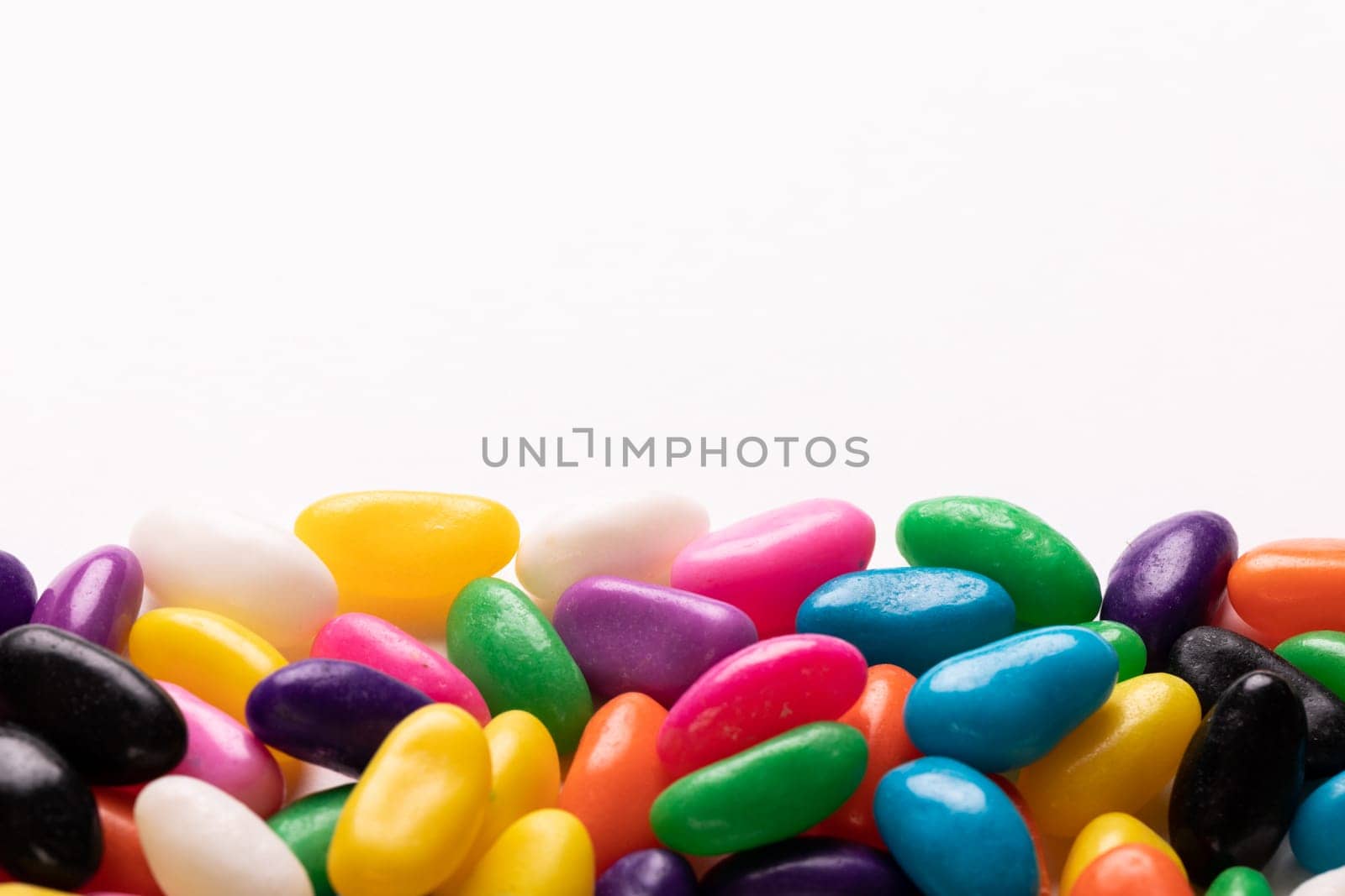 Close-up view of multi colored candies with copy space against white background. unaltered, sweet food and unhealthy eating concept.