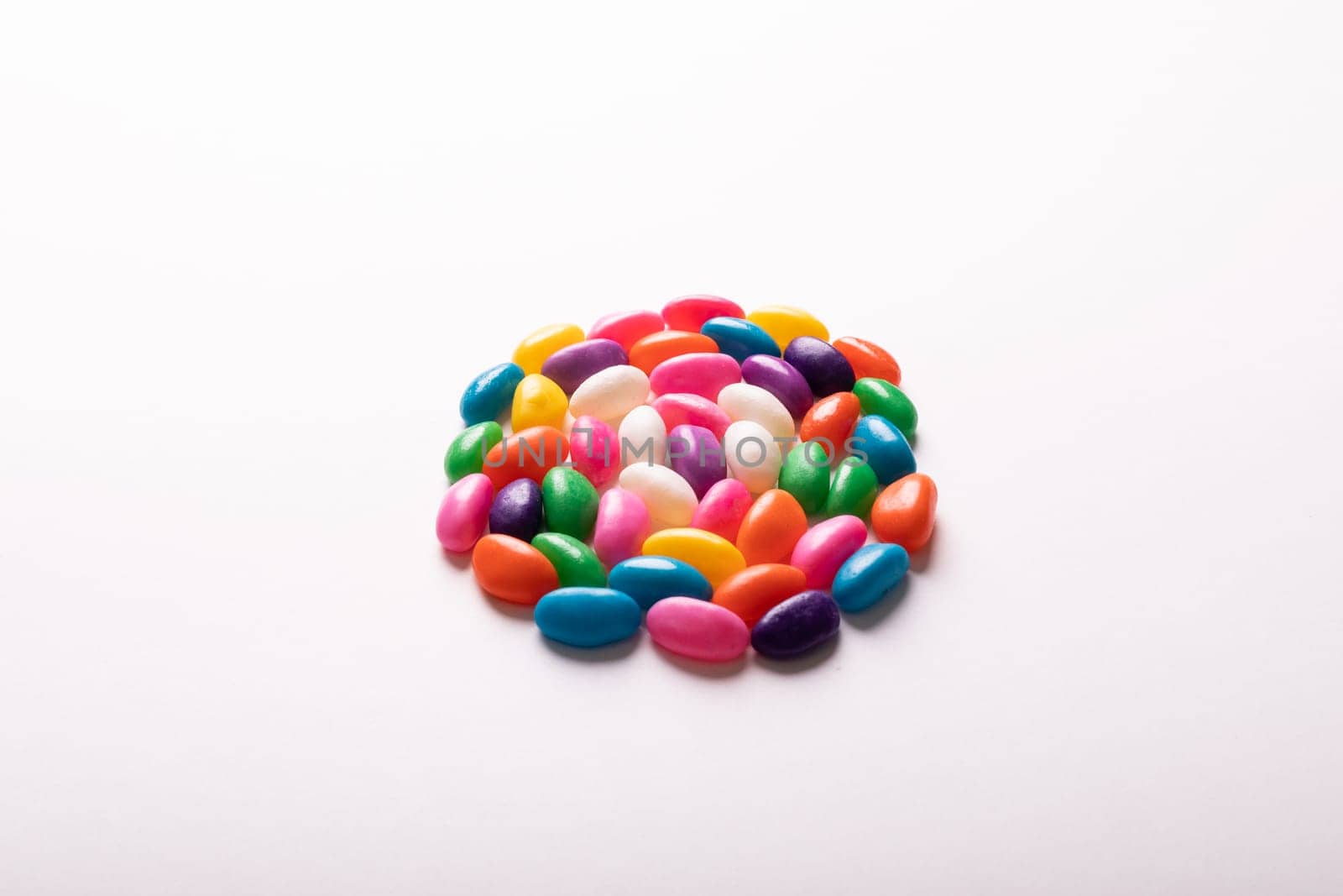 High angle view of multi colored candies arranged in circle by copy space against white background by Wavebreakmedia