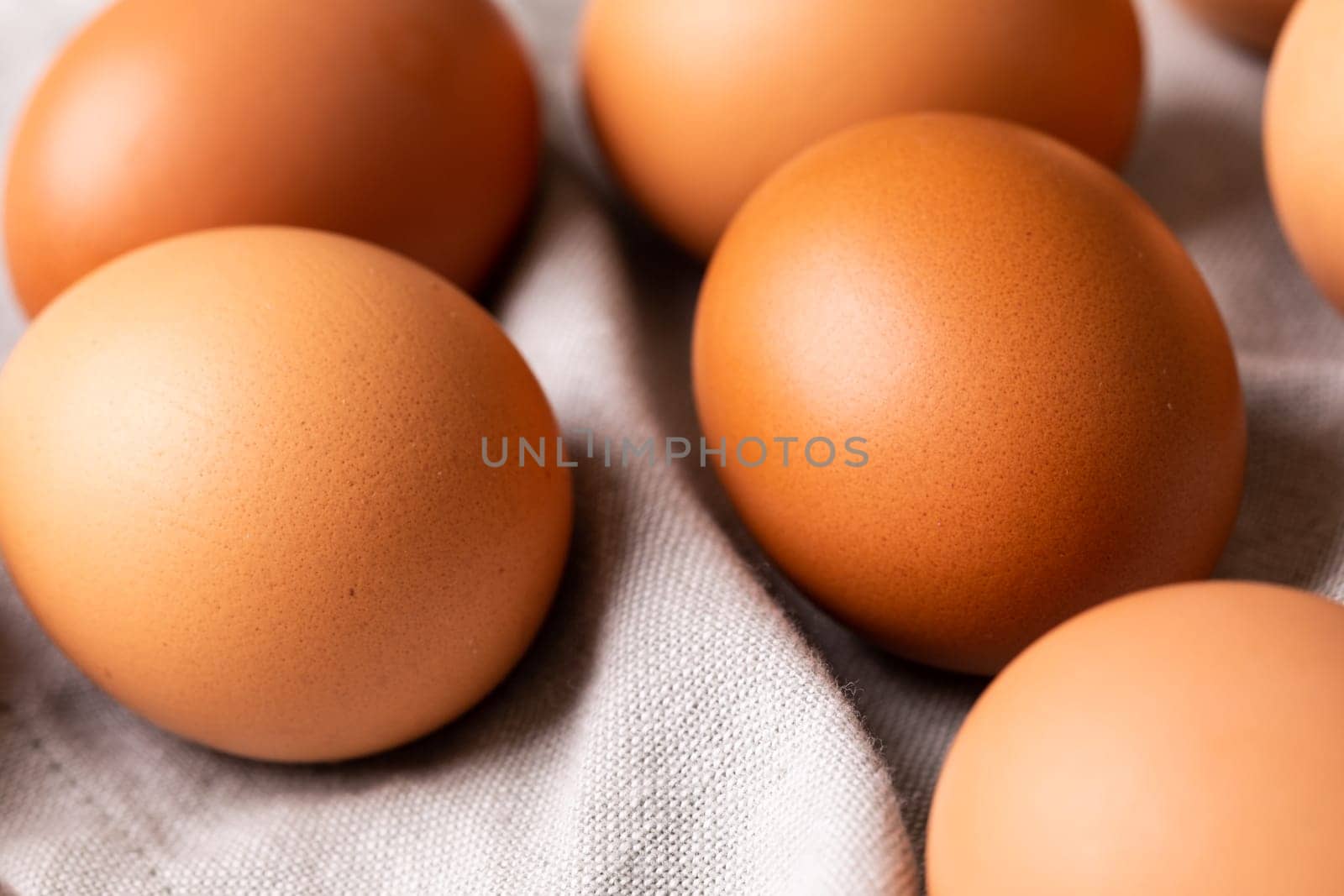 High angle close-up of fresh brown eggs on gray napkin. unaltered, food, healthy eating concept.