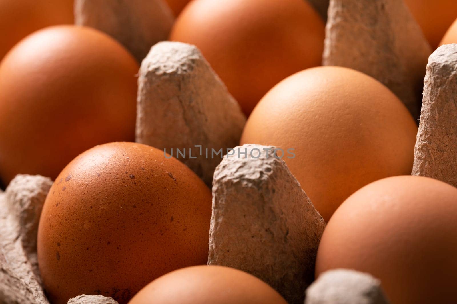 Full frame close-up shot of fresh brown eggs on carton by Wavebreakmedia