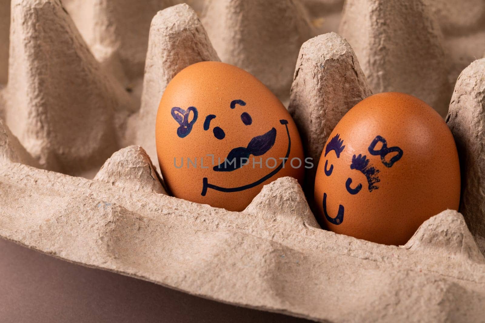 Close-up of creative drawing on brown eggs in carton. unaltered, food, healthy eating, creative, humor concept.