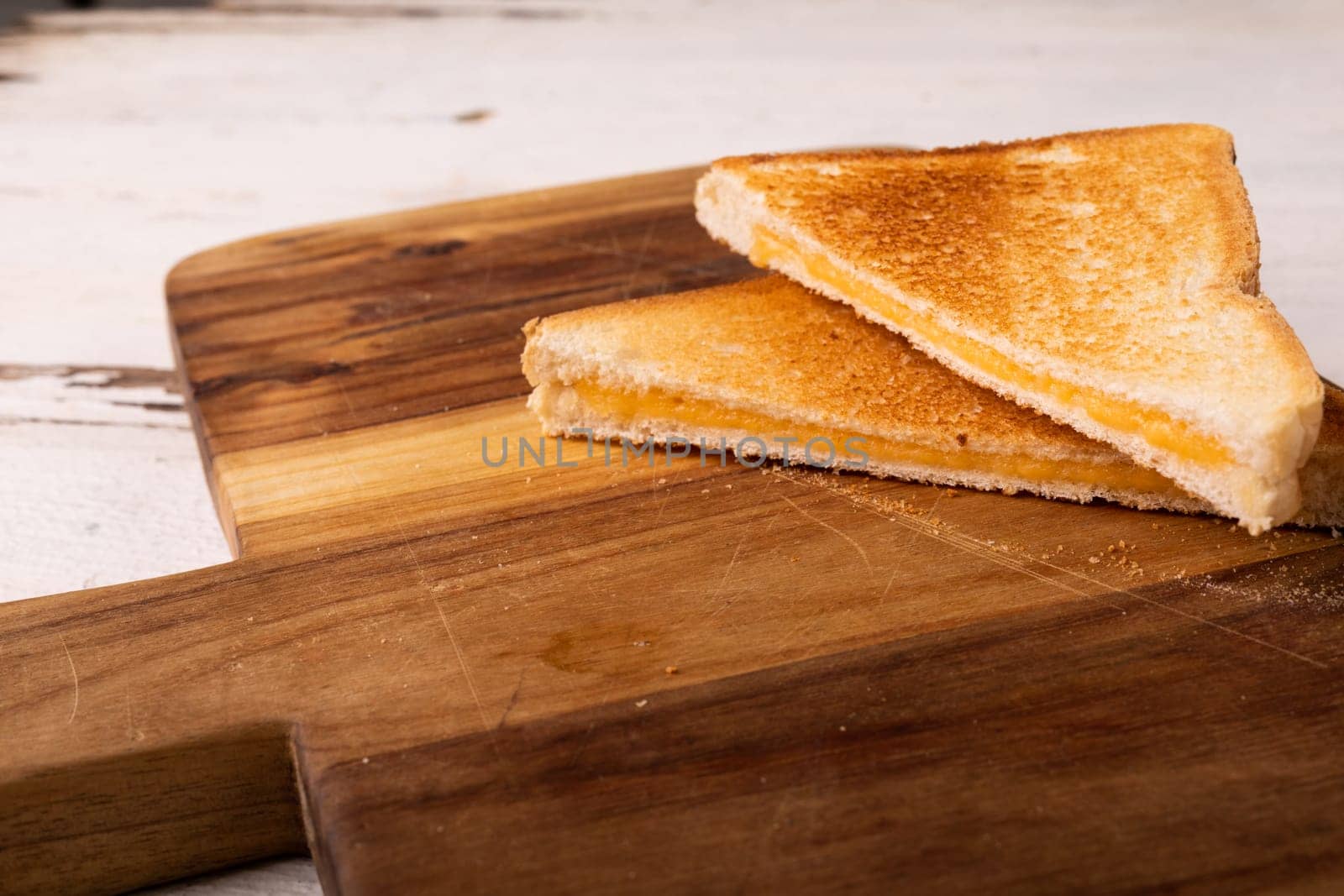 High angle view of fresh cheese sandwich on brown wooden serving board by Wavebreakmedia