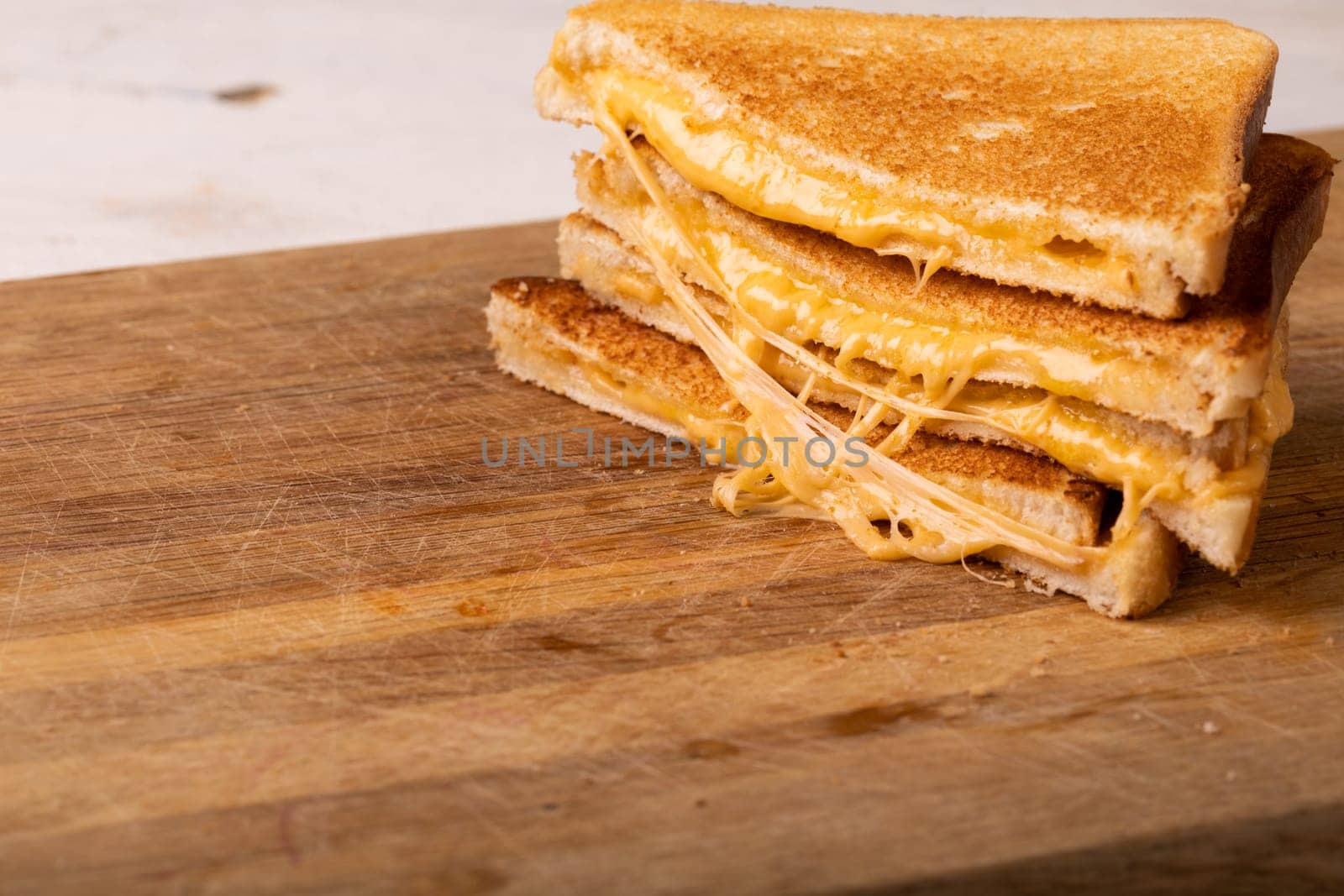 Close-up stack of fresh cheese sandwich served on wooden serving board by Wavebreakmedia