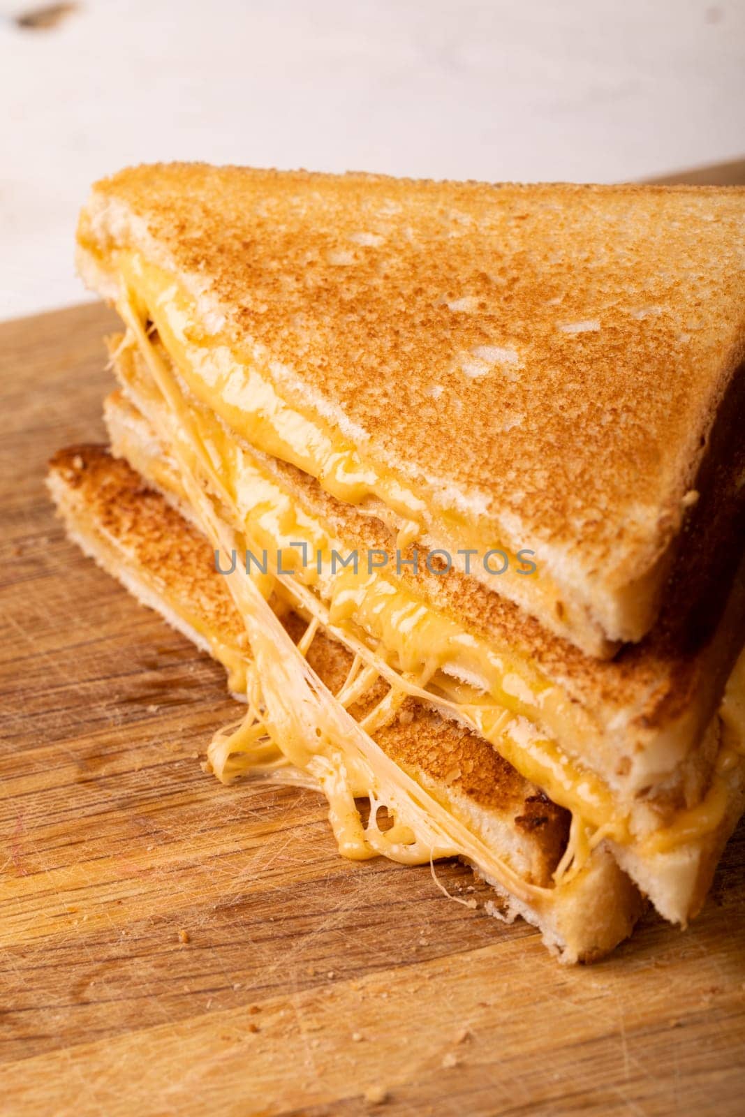 Close-up of fresh cheese sandwich stack on brown wooden serving board by Wavebreakmedia