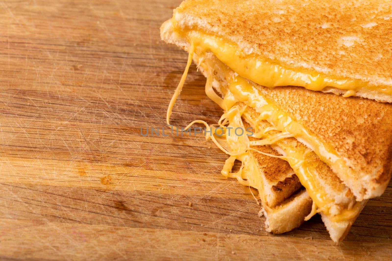 High angle close-up of fresh cheese sandwich on wooden serving board. unaltered, food, unhealthy eating and snack concept.