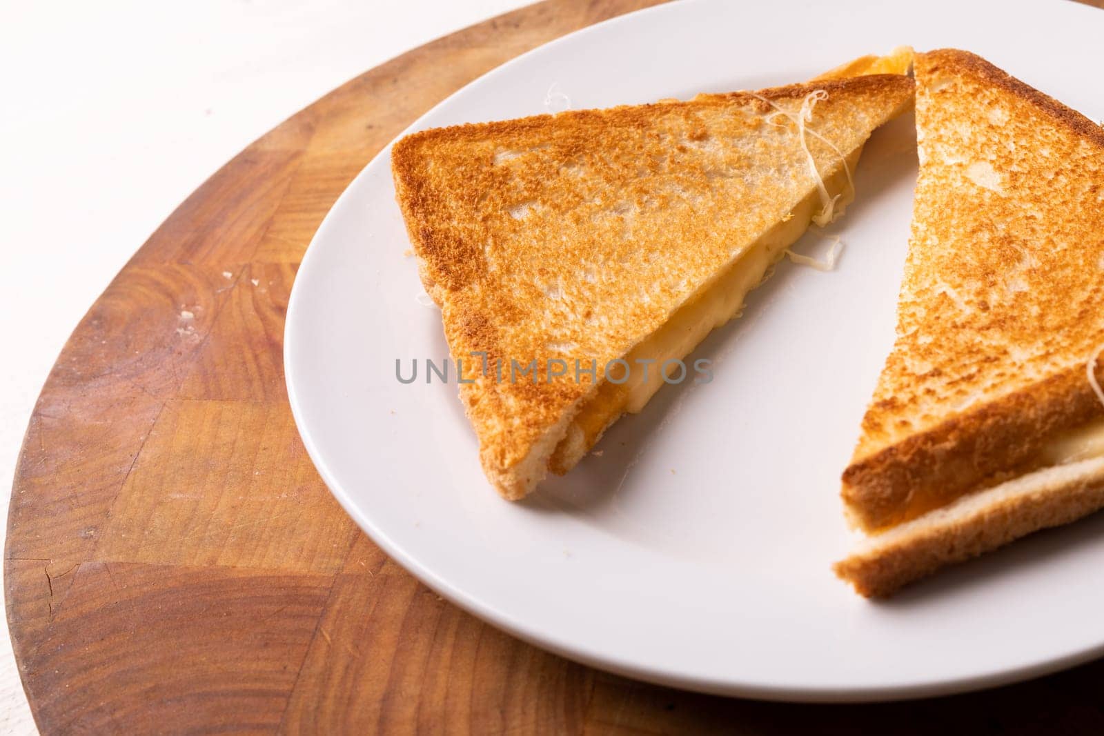 High angle close-up view of fresh cheese sandwich served in plate on wooden table by Wavebreakmedia
