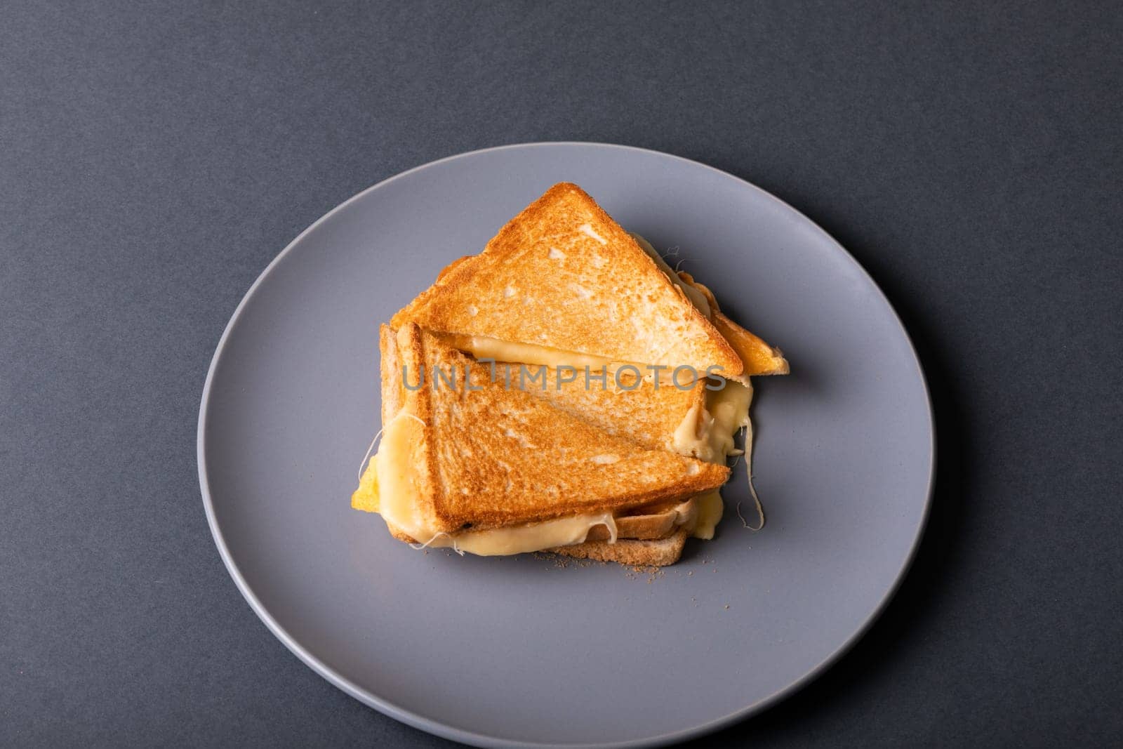 Directly above view of fresh cheese toast sandwich served in plate on blue background. unaltered, food, unhealthy eating and snack concept.