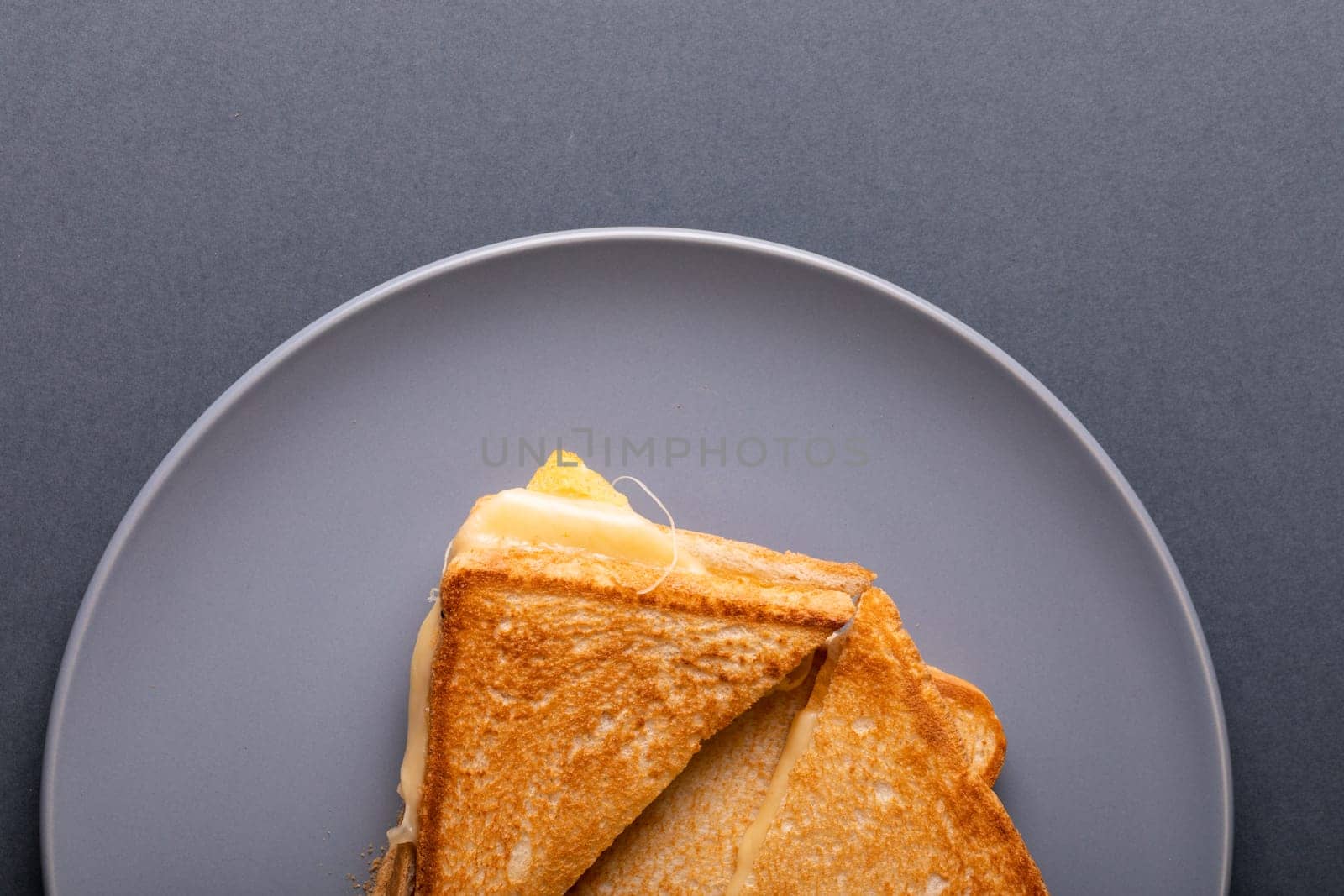 Overhead view of fresh cheese toast sandwich served in plate on blue background. unaltered, food, unhealthy eating and snack concept.