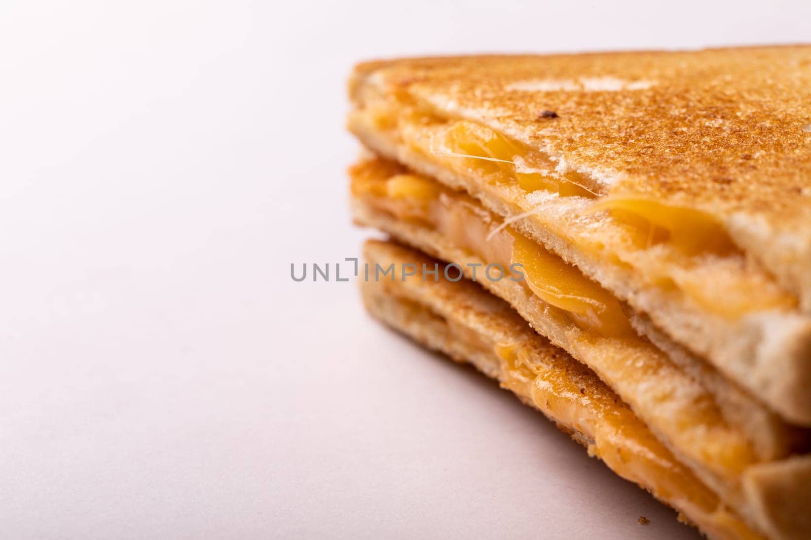Close-up of fresh cheese toast sandwich served by copy space on white background. unaltered, food, unhealthy eating and snack concept.