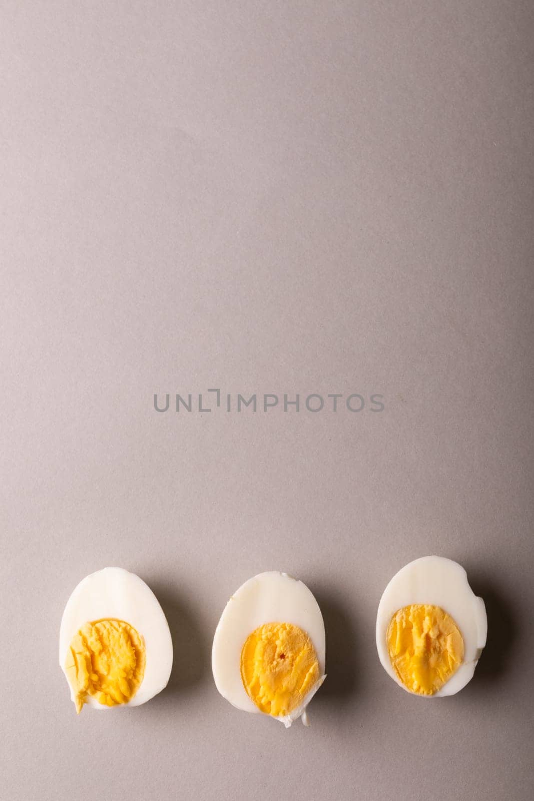 Overhead view of copy space with fresh boiled white egg halves against gray background by Wavebreakmedia