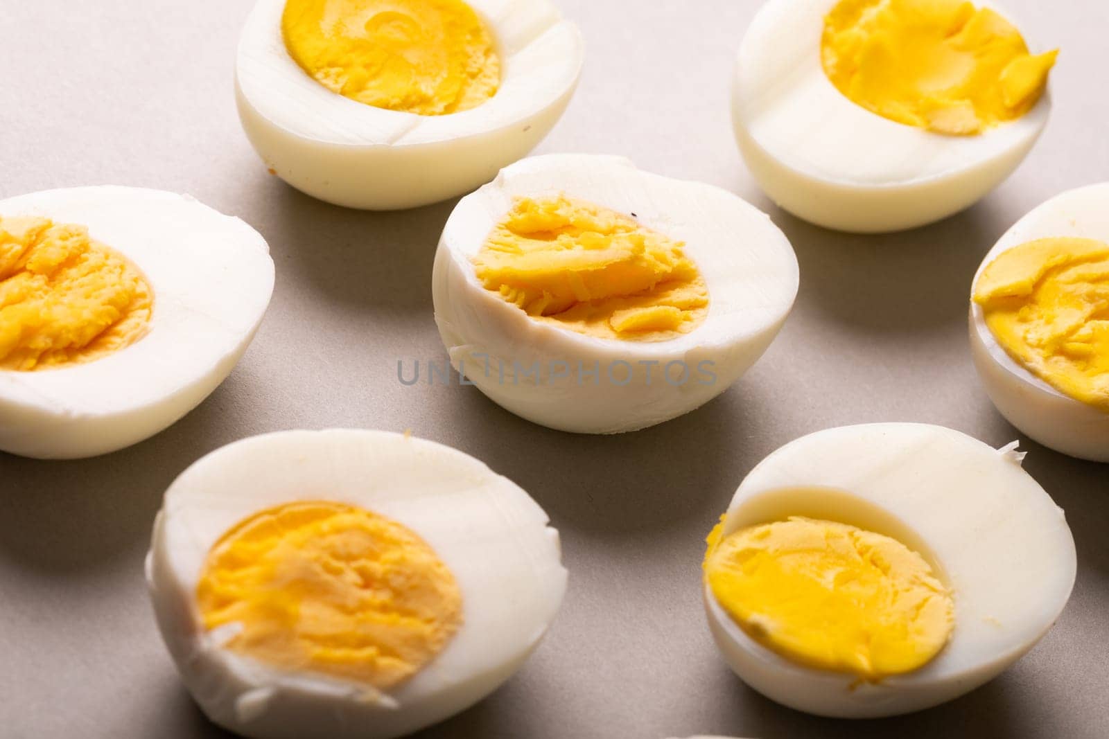 High angle close-up of fresh white boiled eggs with yellow yolks on gray table by Wavebreakmedia