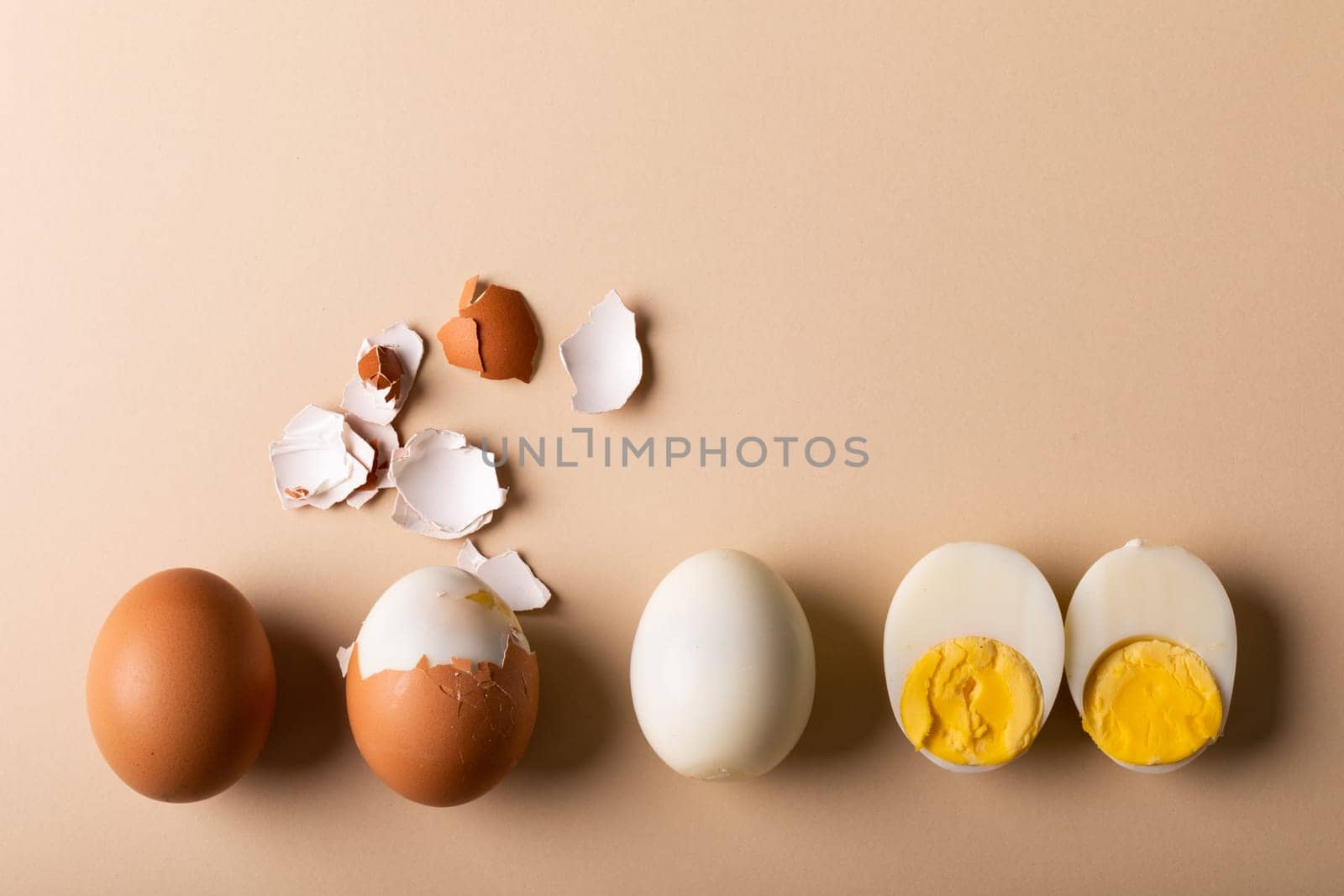 Overhead view of fresh boiled brown and white eggs on pink background with copy space. unaltered, food, healthy eating and organic concept.