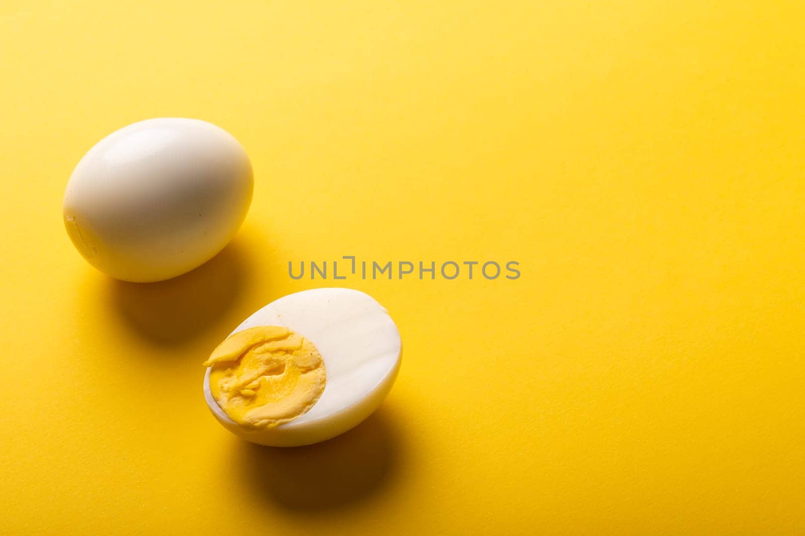 High angle view of freshly boiled white eggs with copy space on yellow background by Wavebreakmedia