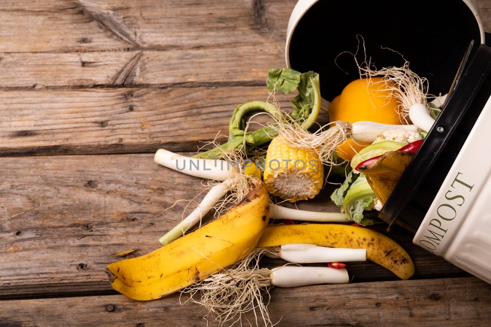 Overhead view of spilled organic waste in compost bin over wooden table by Wavebreakmedia