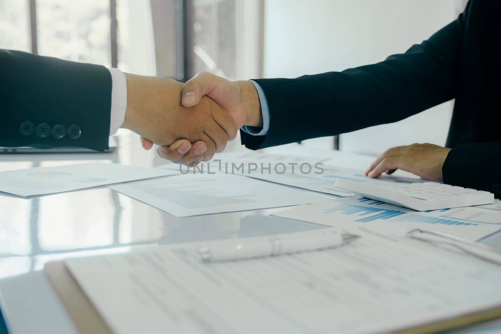 Close up businessman shaking hands with the client after finish the meeting. by ijeab