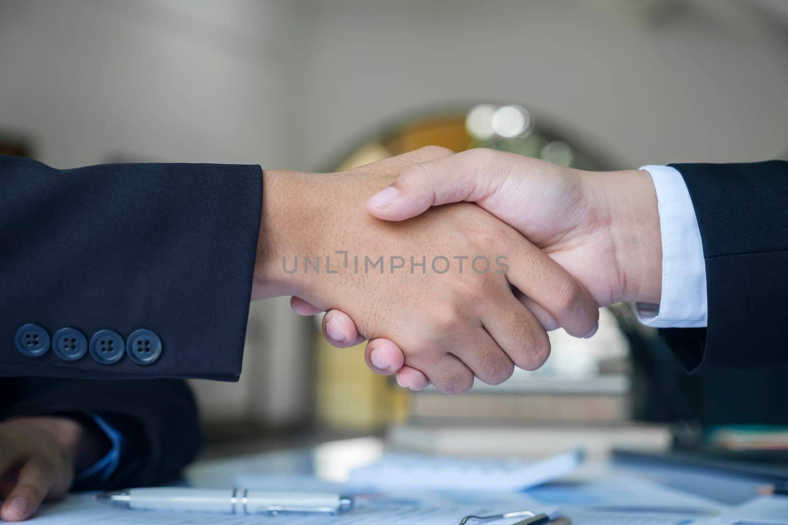 The businessman and his partnership are agree with their concept. The image of two businessman are shaking hands together. The successful persons are shaking hands after have a good deal with their meeting.