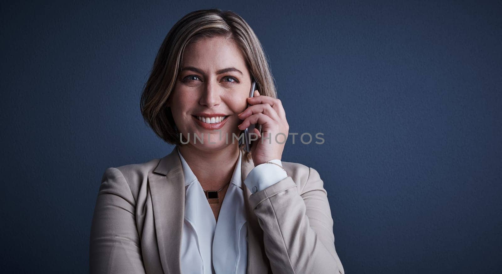 Im always happy to give advice. Studio portrait of an attractive young corporate businesswoman making a call against a dark background
